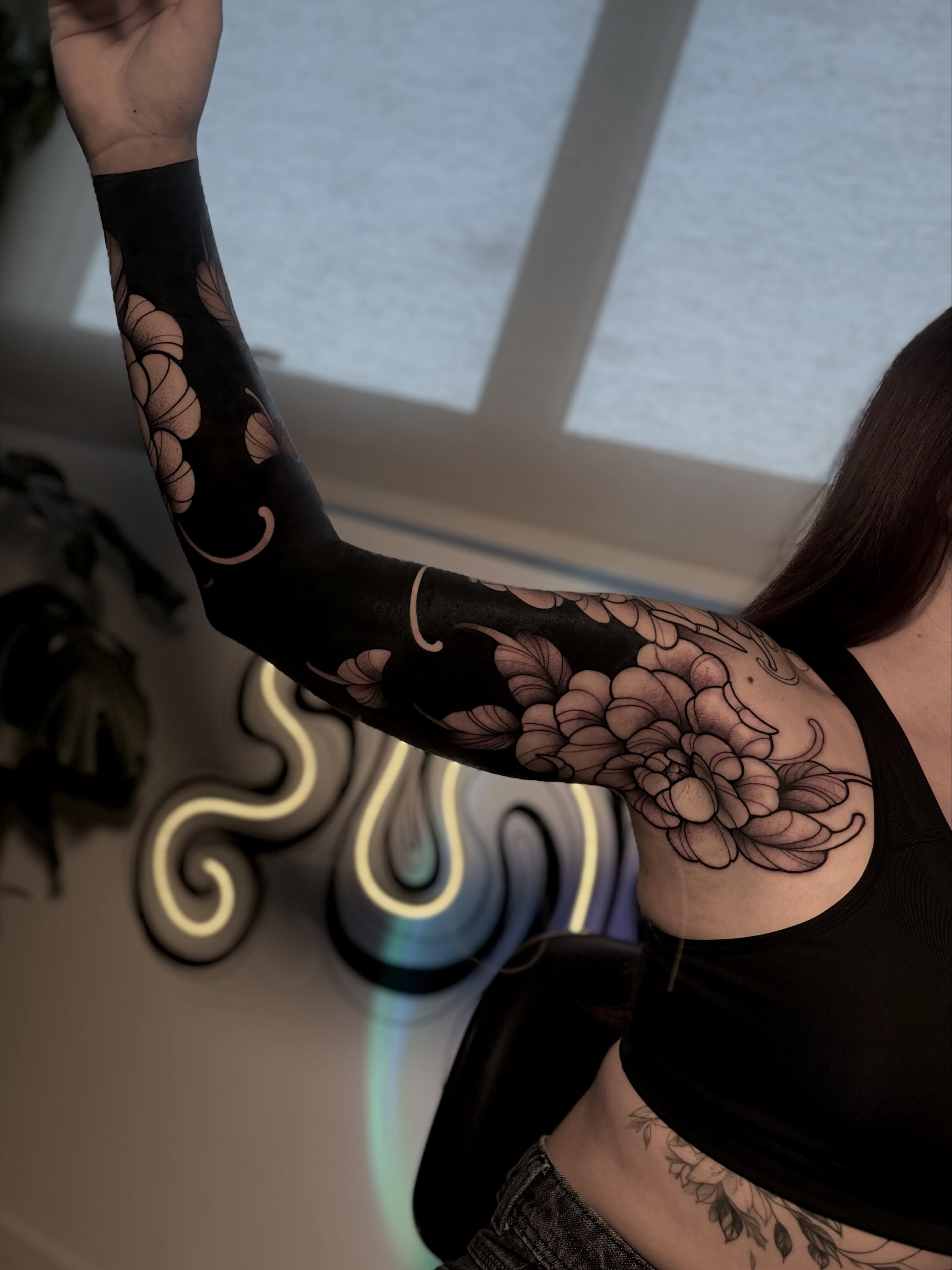 Floral design black and grey tattoo on the upper arm by Gabrieli Folha