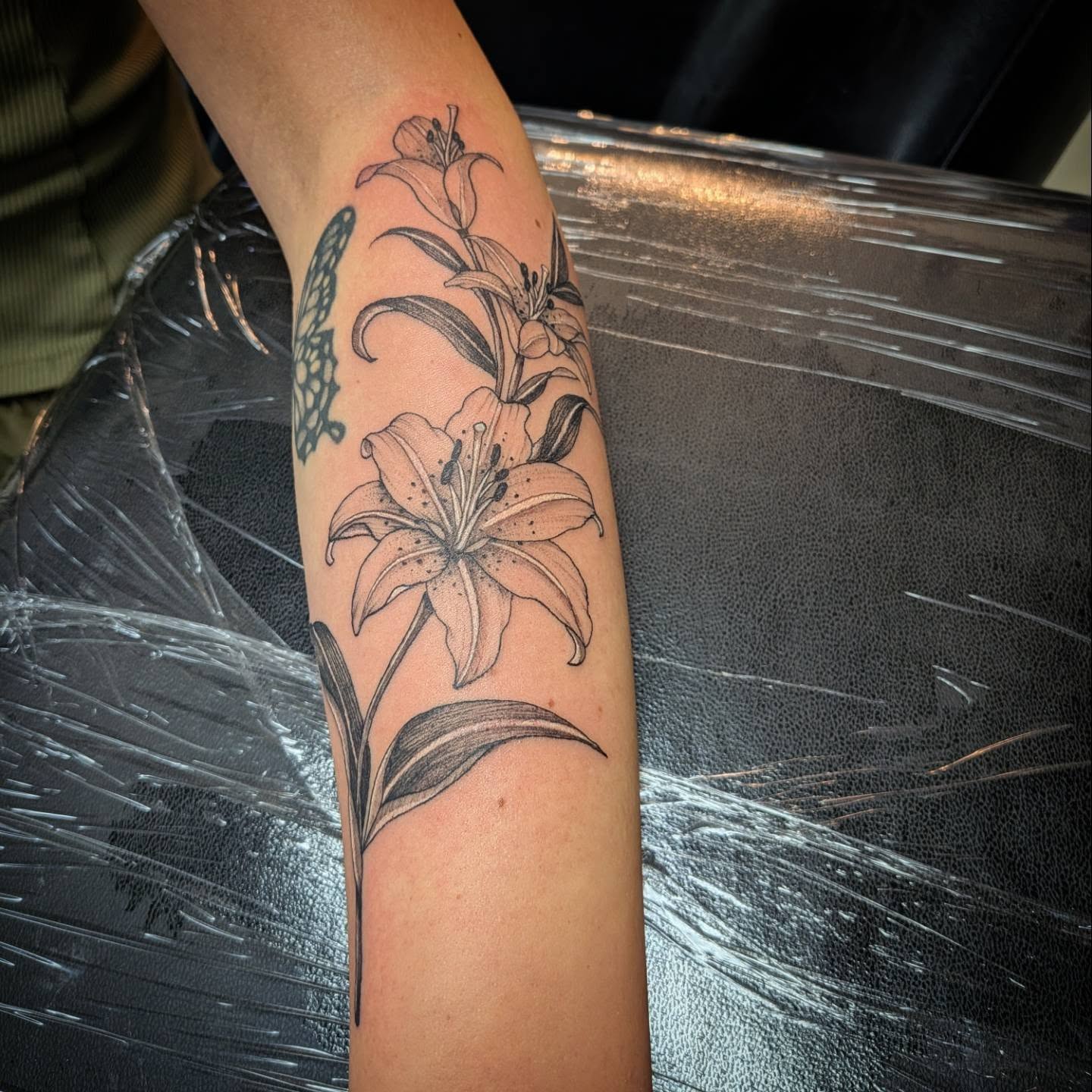 Lily black and grey tattoo on the forearm by 𝕸𝖆𝖉𝖎 (𝕸𝖆𝖉 𝕯𝖔𝖌)