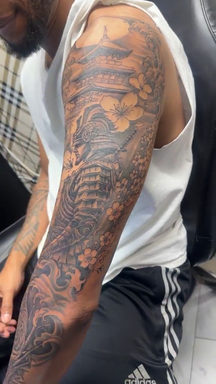 Pagoda and cherry blossoms Japanese tattoo on the upper arm by Jose Onasis Disla, New York, New York
