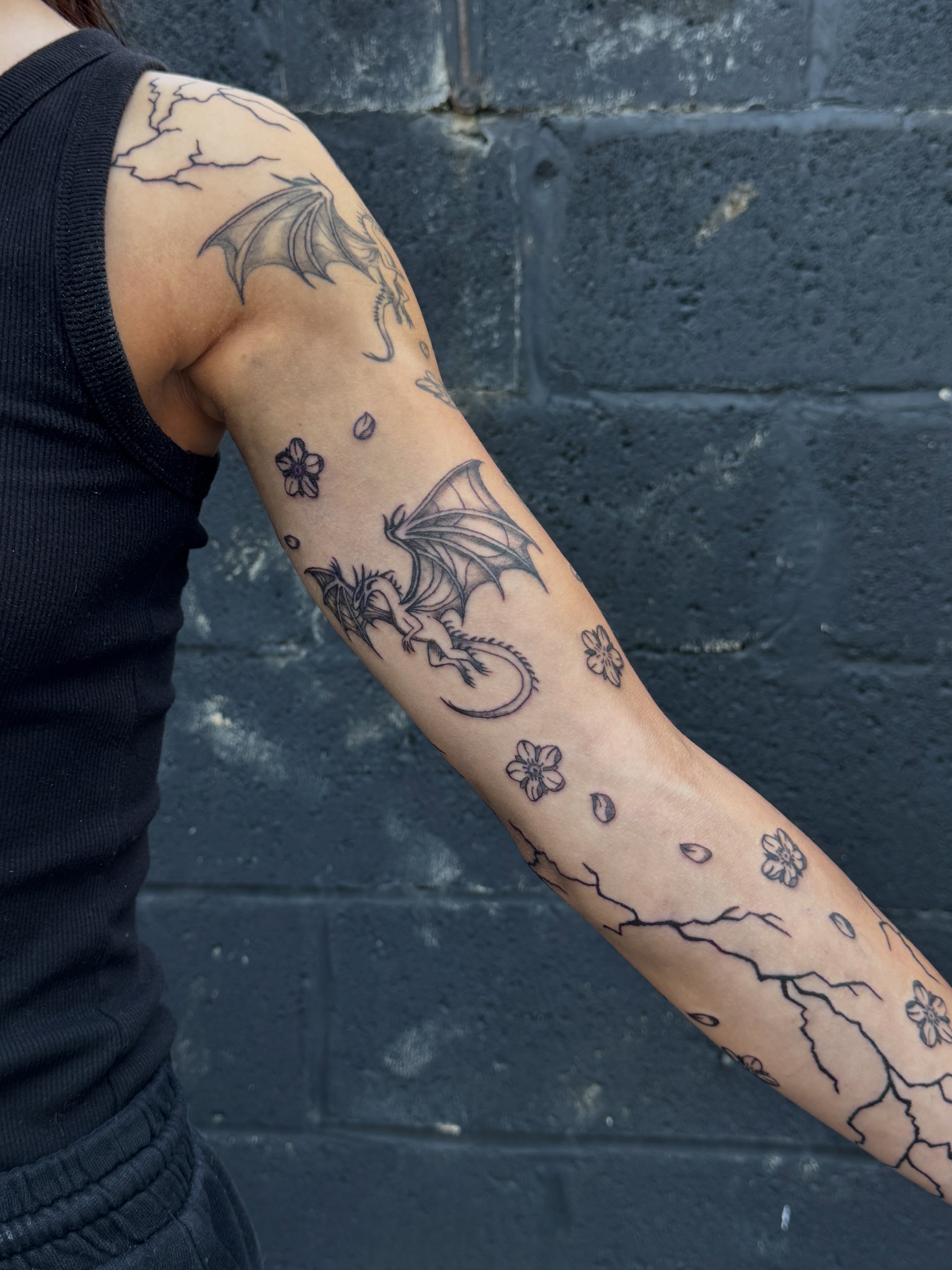 Dragons and cherry blossoms black and grey tattoo on the forearm by dev
