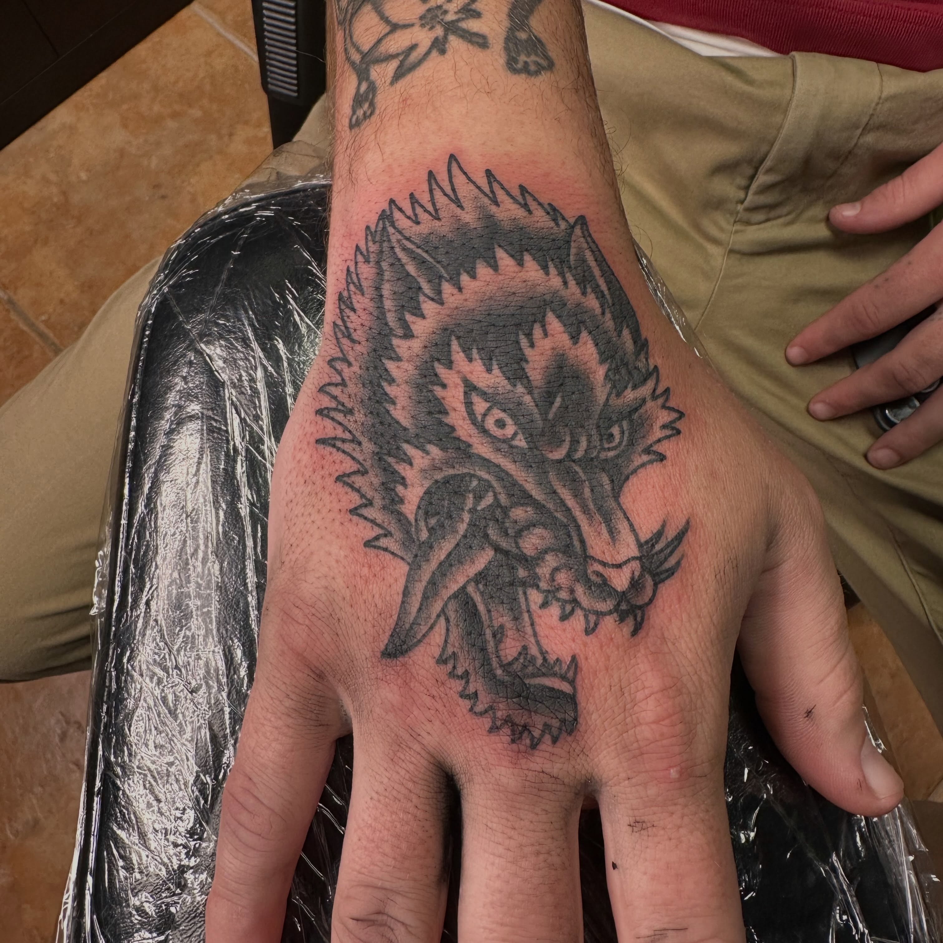 Wolf black and grey tattoo on the hand by Dallas Davis