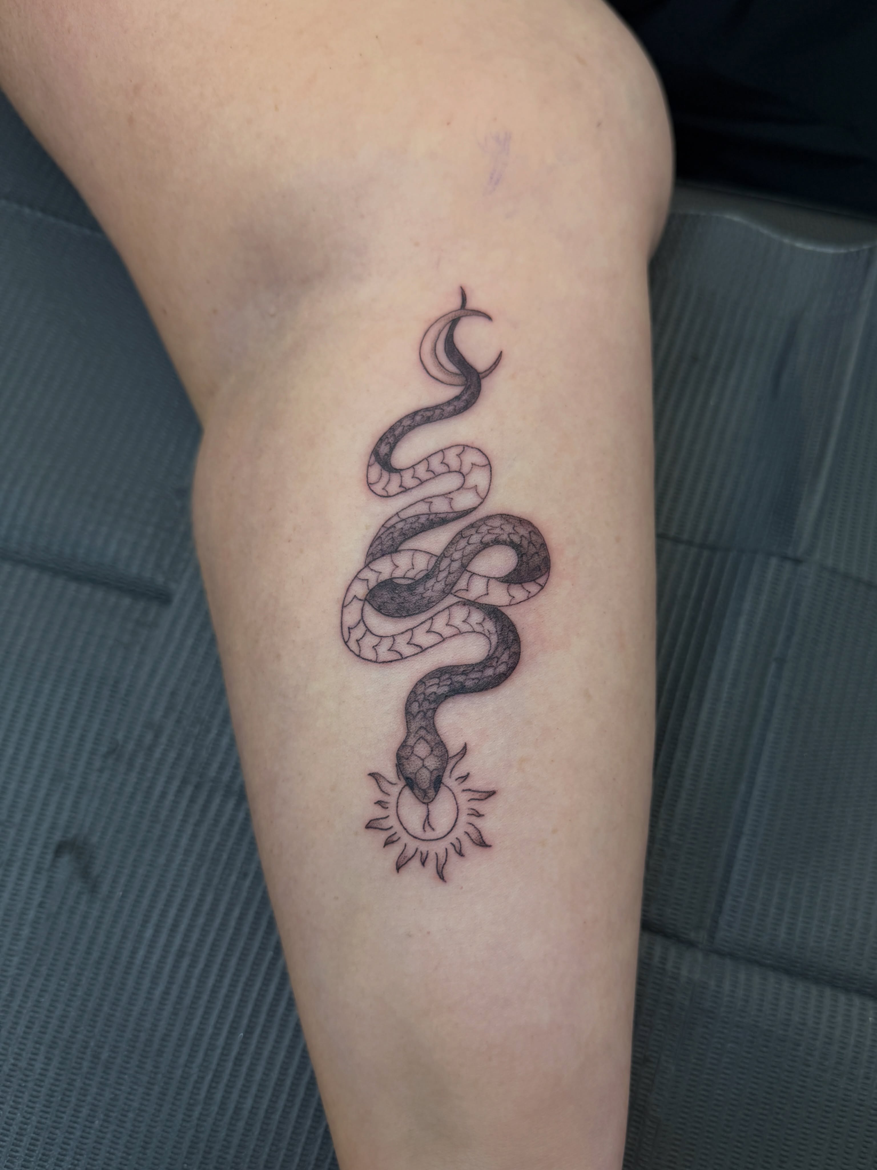 Snake and sun realism tattoo on the forearm by Kiana Hope