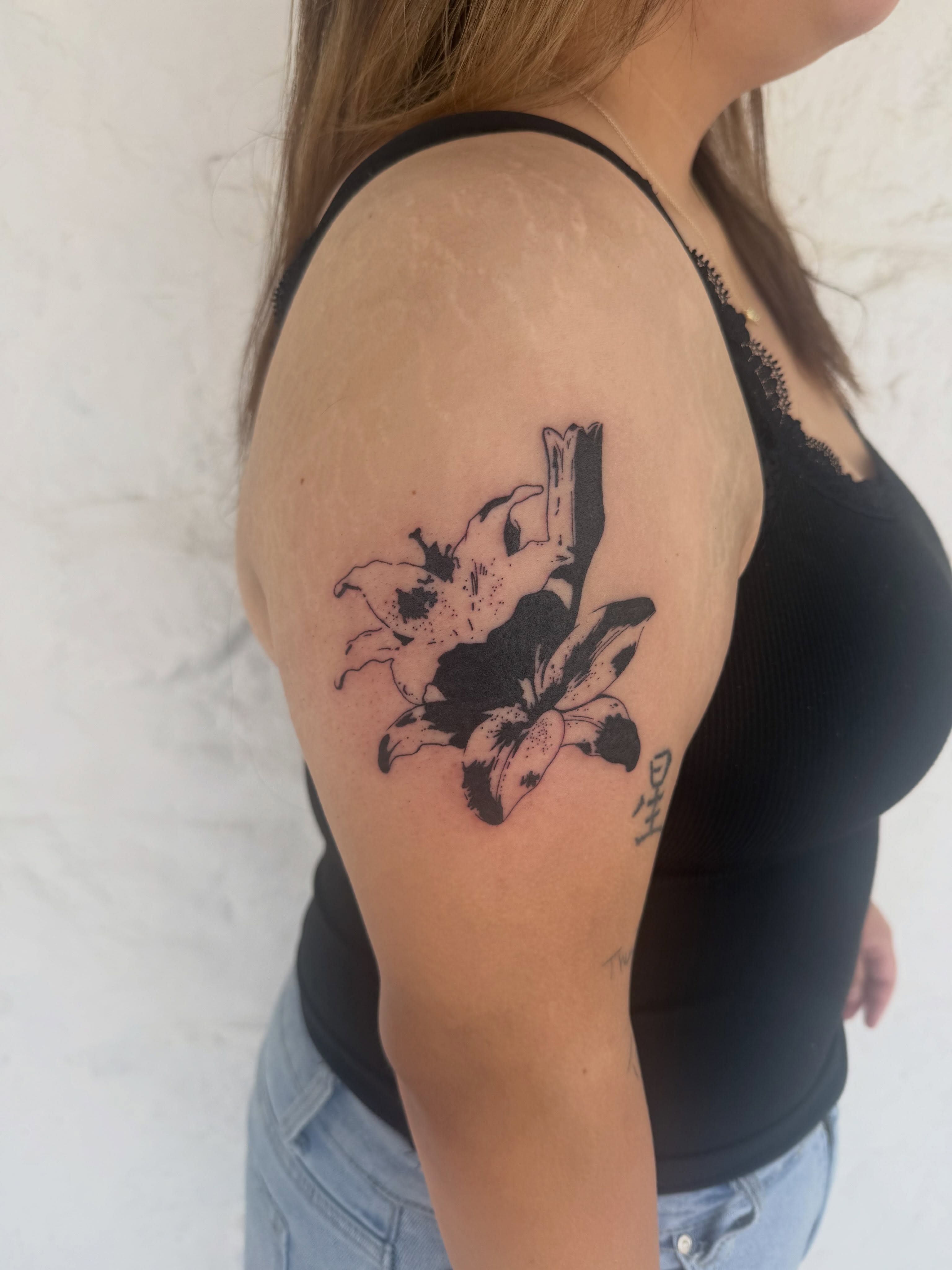 Flower black and grey tattoo on the shoulder by sarah