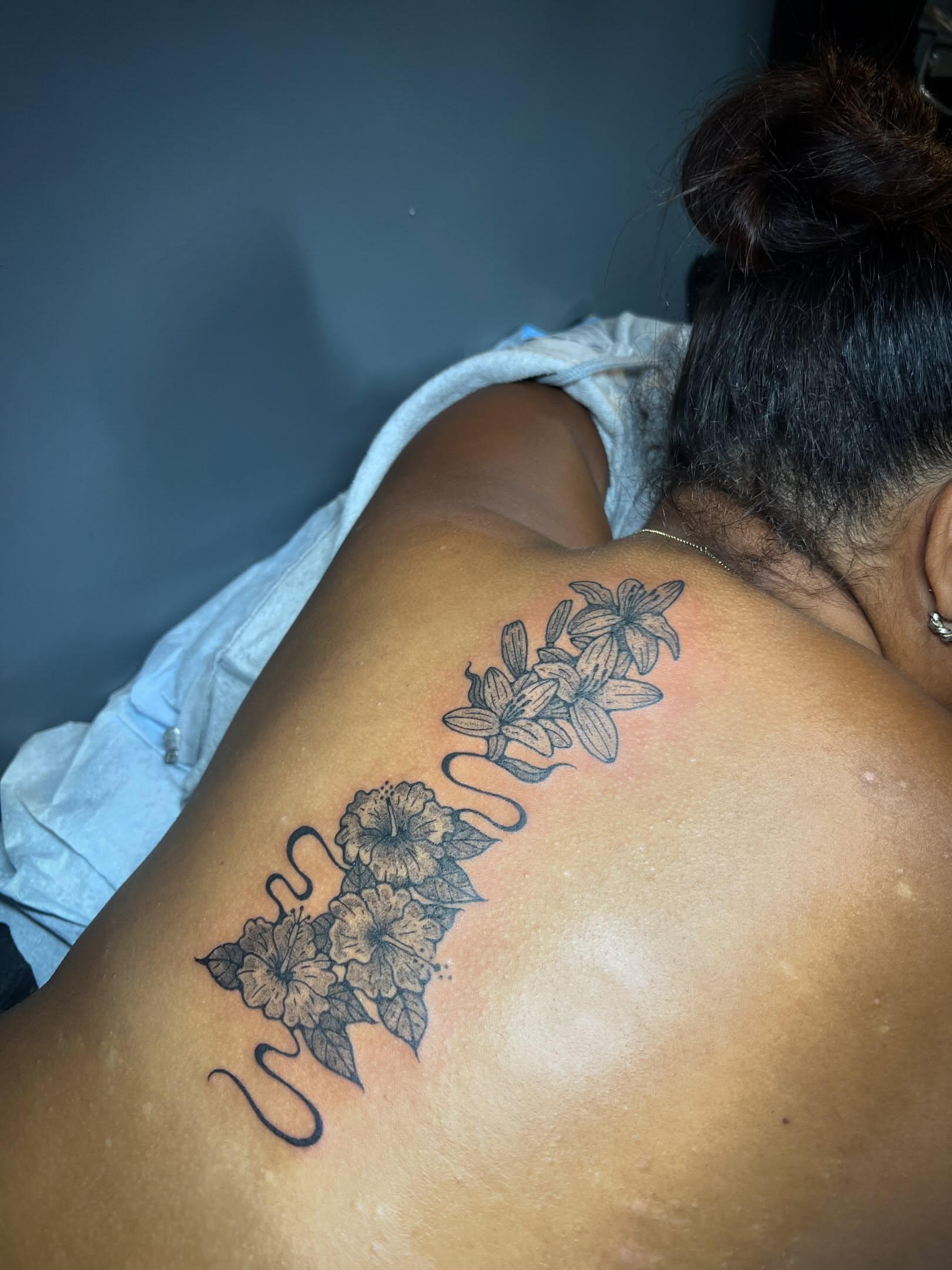 Flowers black and grey tattoo on the back by Tattoo Kayla