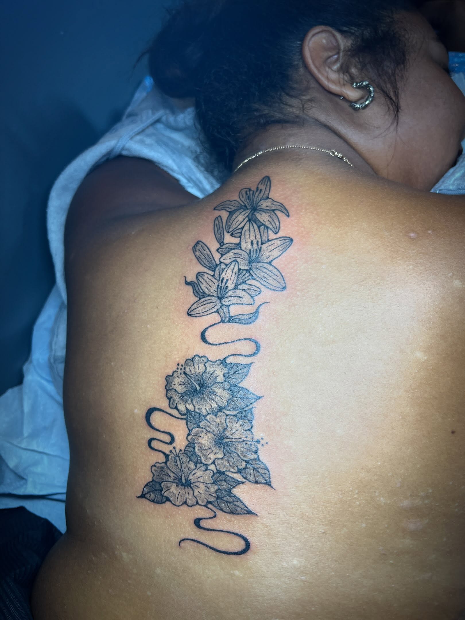 Flowers black and grey tattoo on the back by Tattoo Kayla