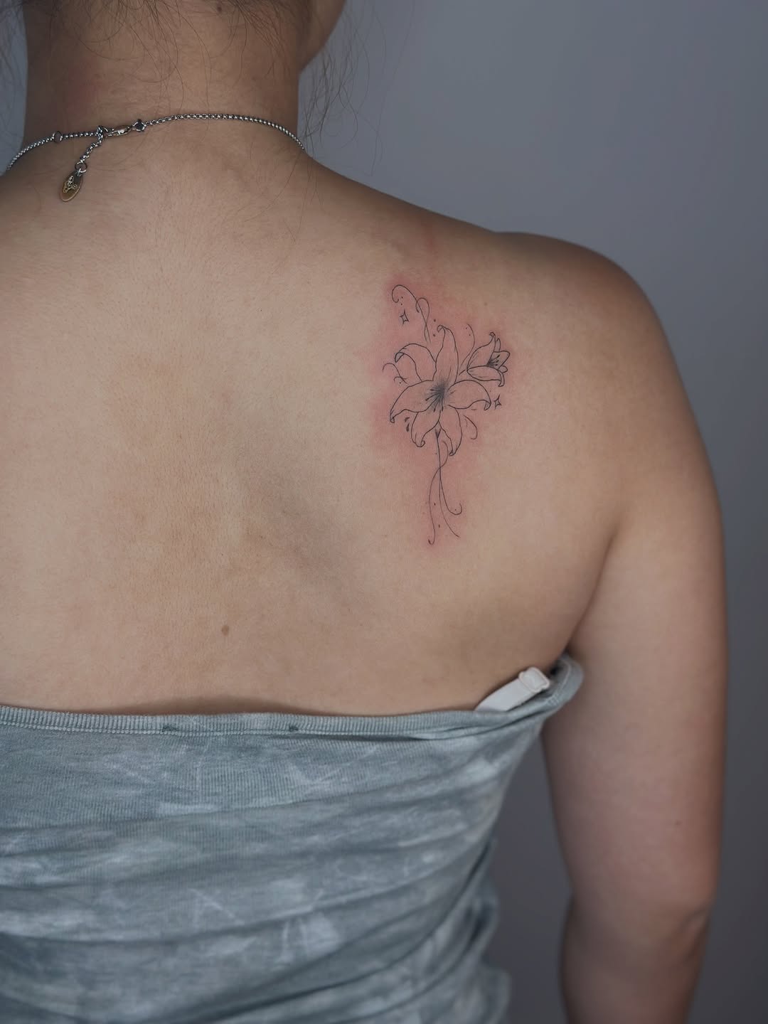 Lily flower fine line tattoo on the shoulder by Cherry🥀