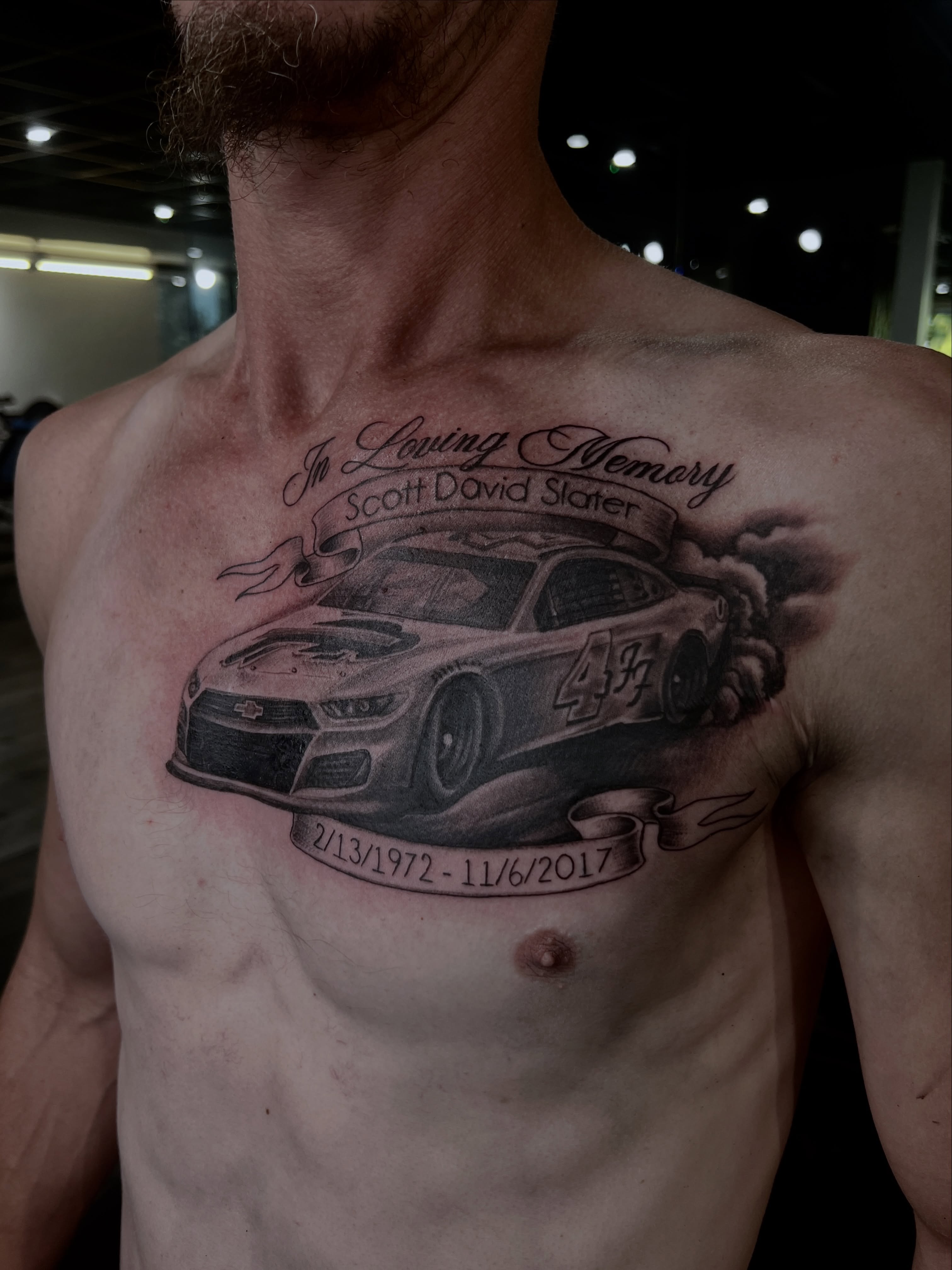 Race car black and grey tattoo on the chest by Tattoo Artist Mimzi PMA