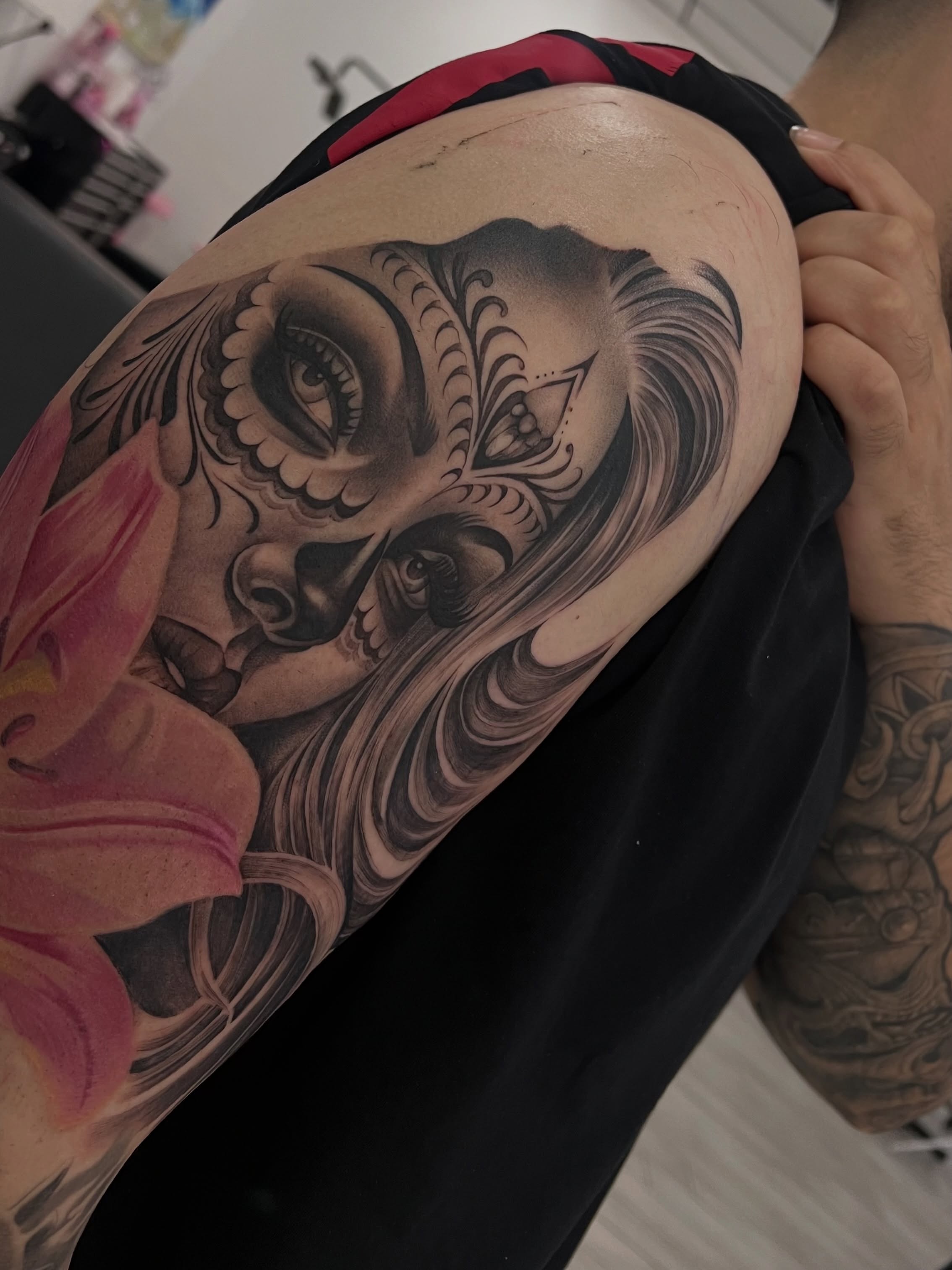 Sugar skull with lily realism tattoo on the shoulder by Espi
