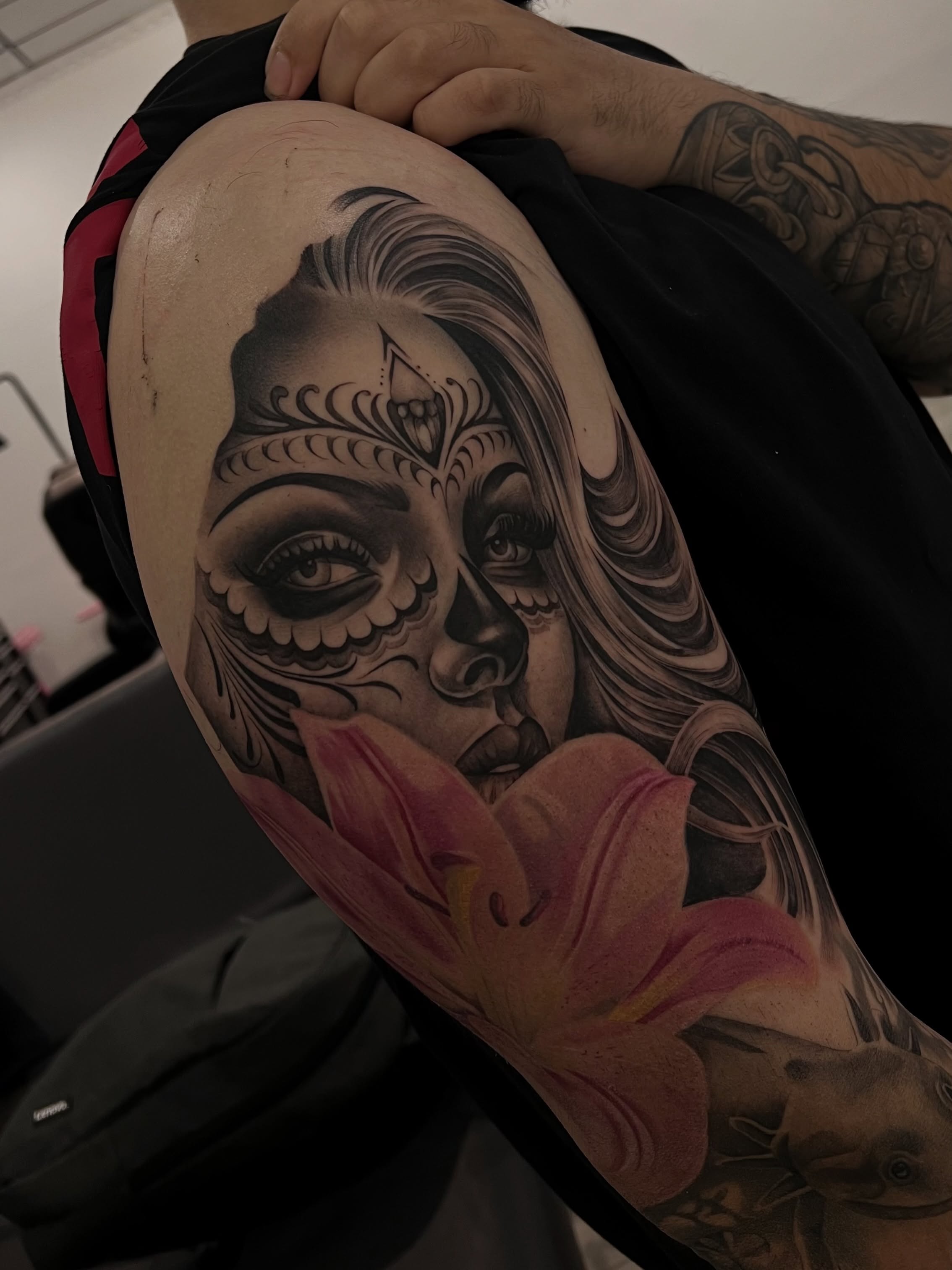 Sugar skull with lily realism tattoo on the thigh by Espi