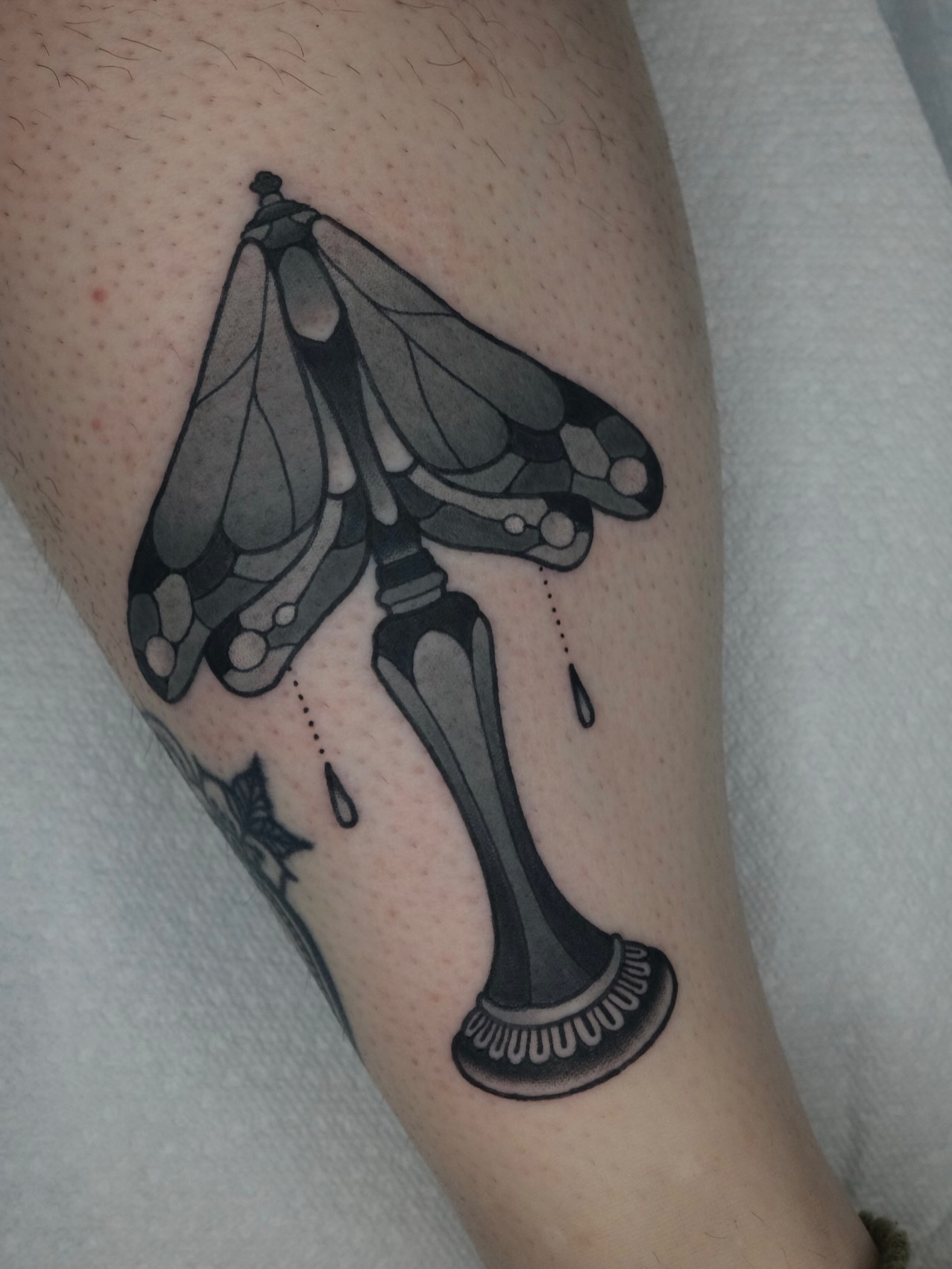 Moth and skeleton leg geometric tattoo on the forearm by James Maxwell