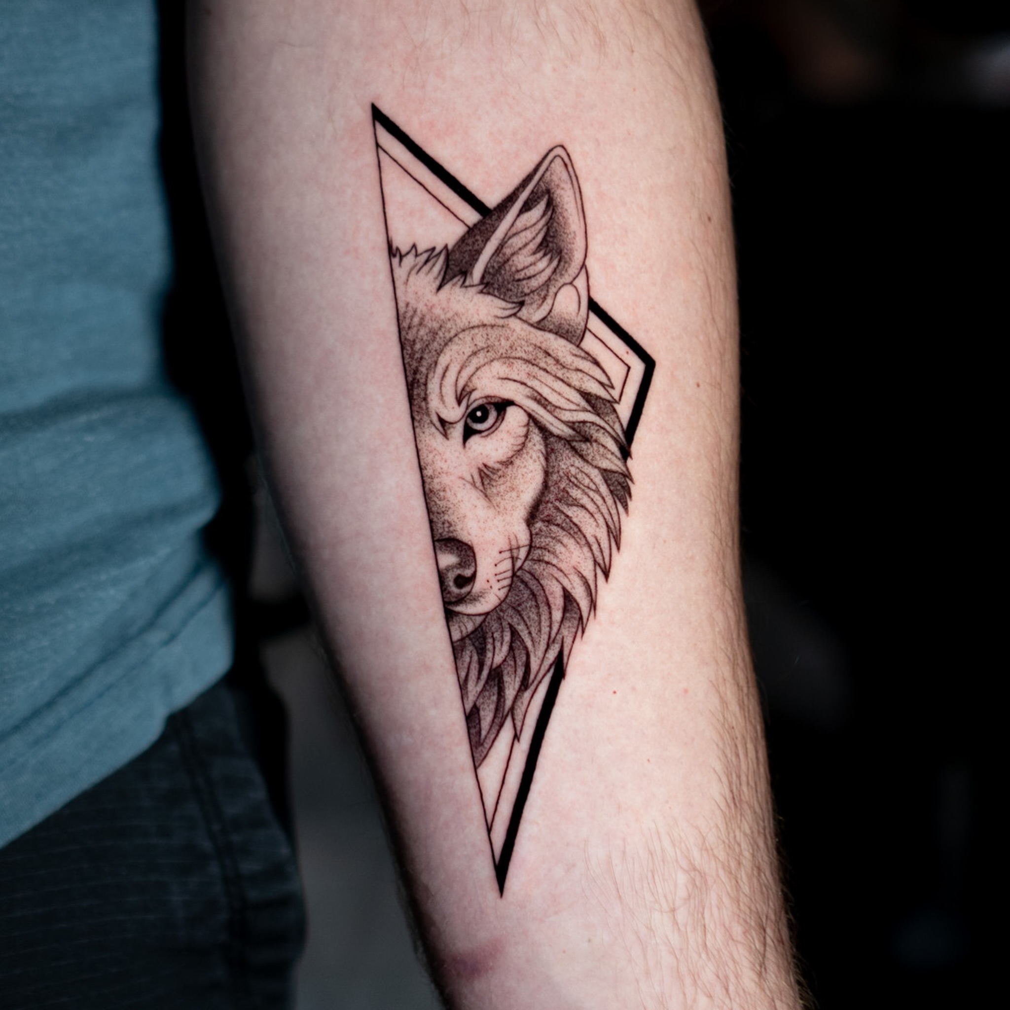 Wolf geometric tattoo on the forearm by Jorden Ruppe
