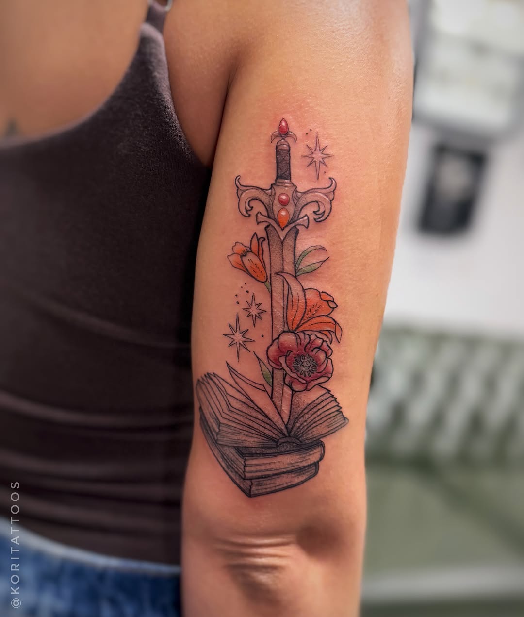 Book with flowers and sword dotwork tattoo on the forearm by Kori Millhimes