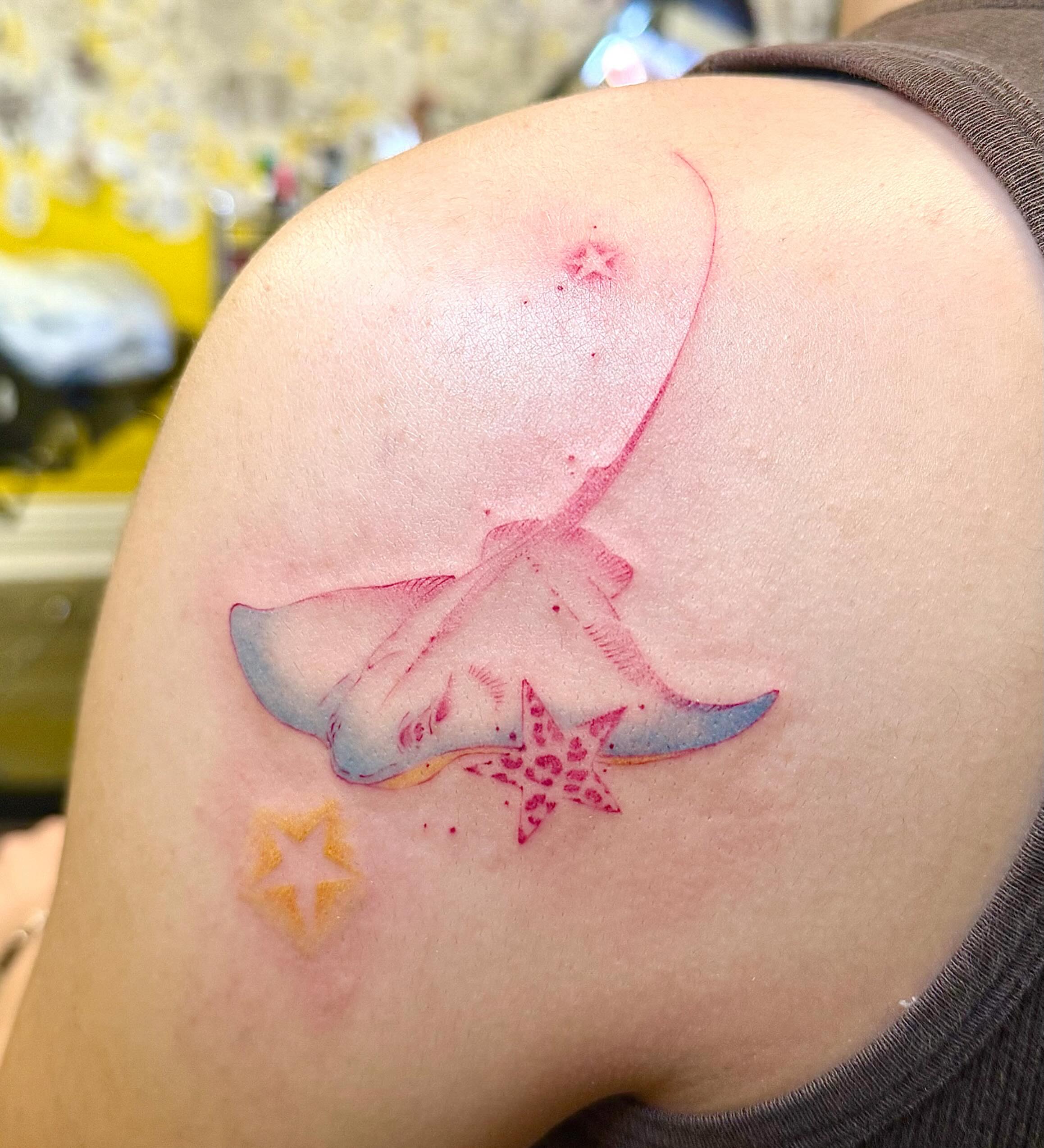 Ray and star watercolor tattoo on the shoulder by Echo