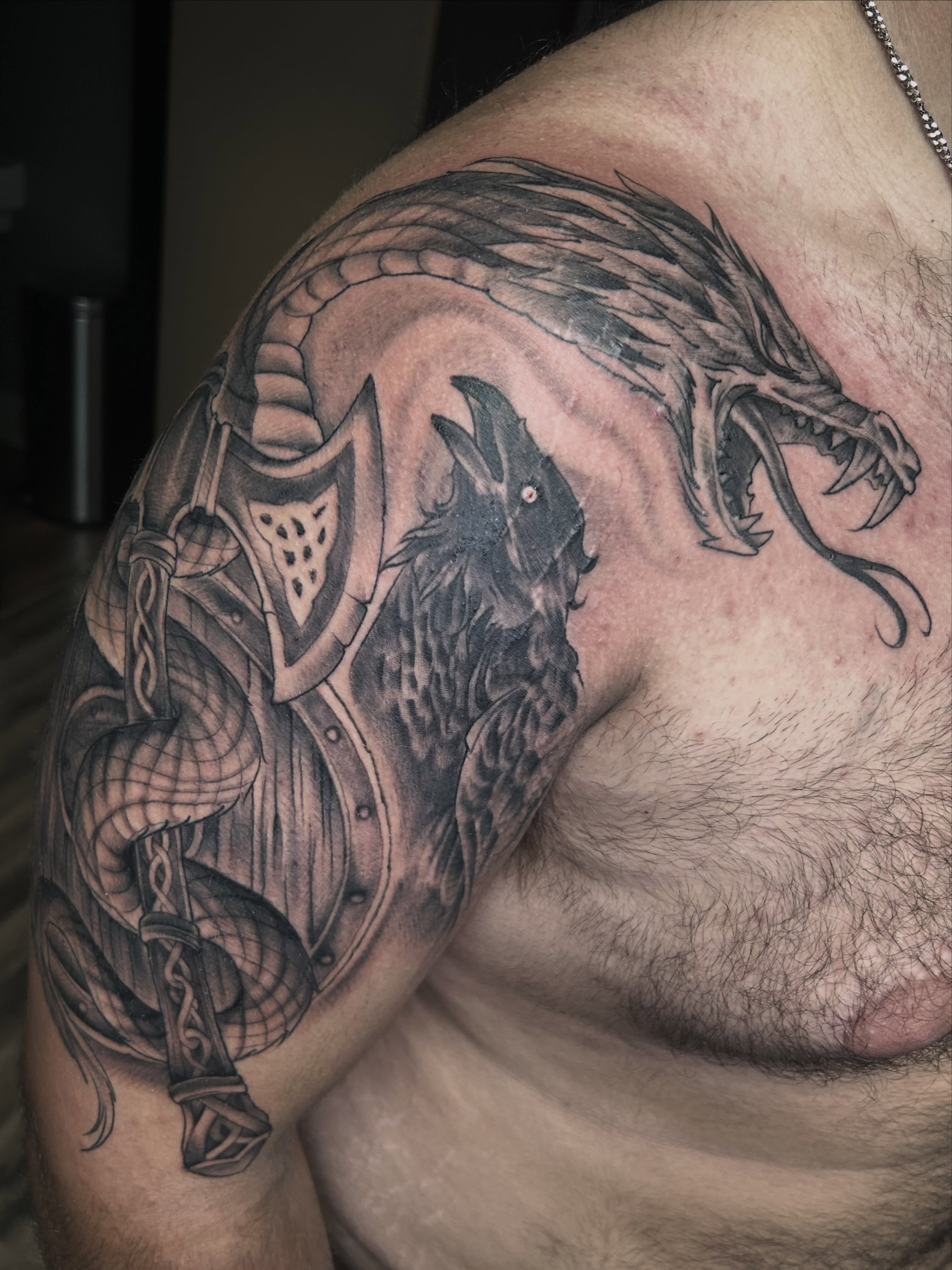 Dragon and raven realism tattoo on the shoulder by Dan Schuster