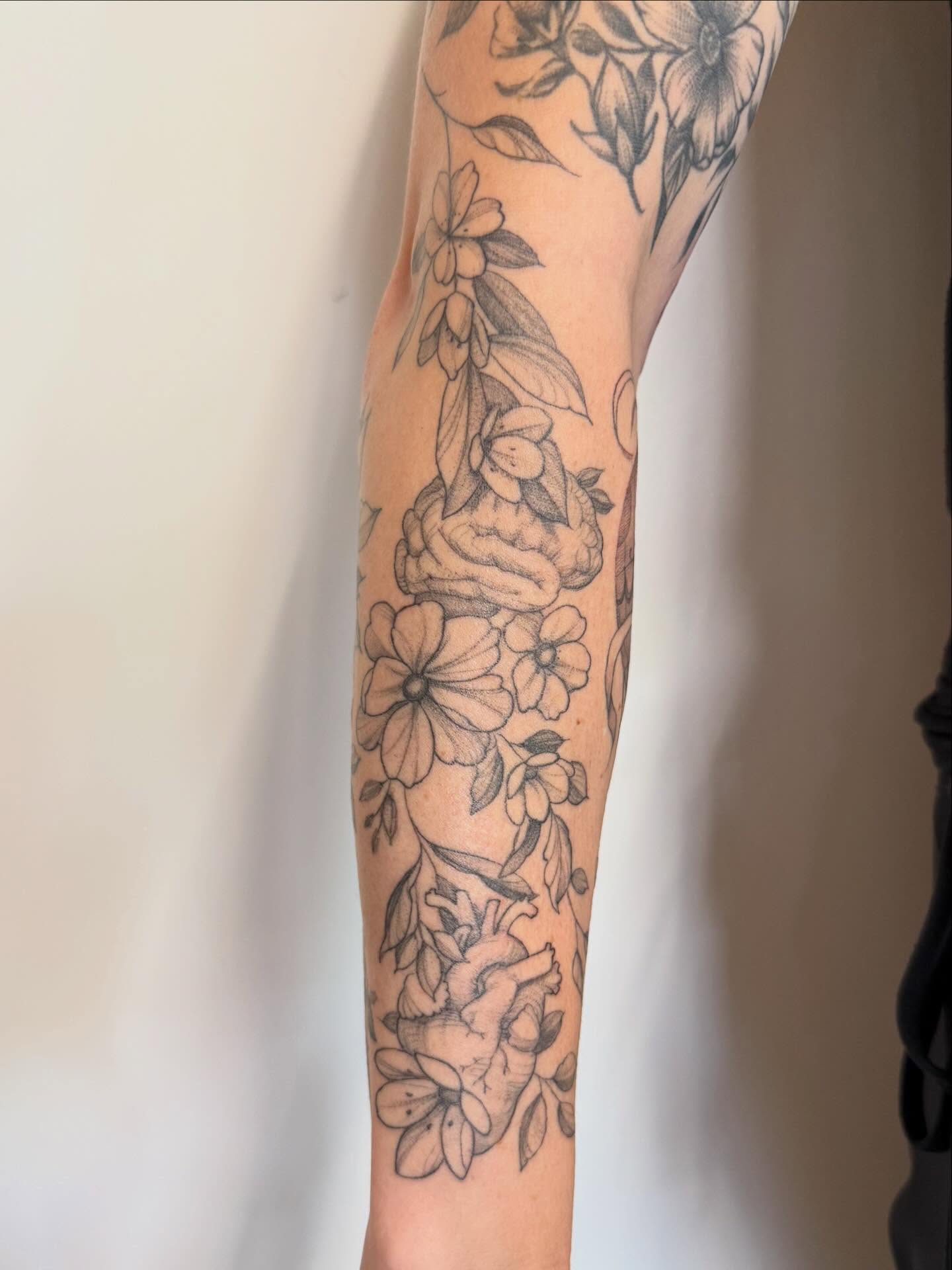 Floral arrangement black and grey tattoo on the forearm by Peter Harren