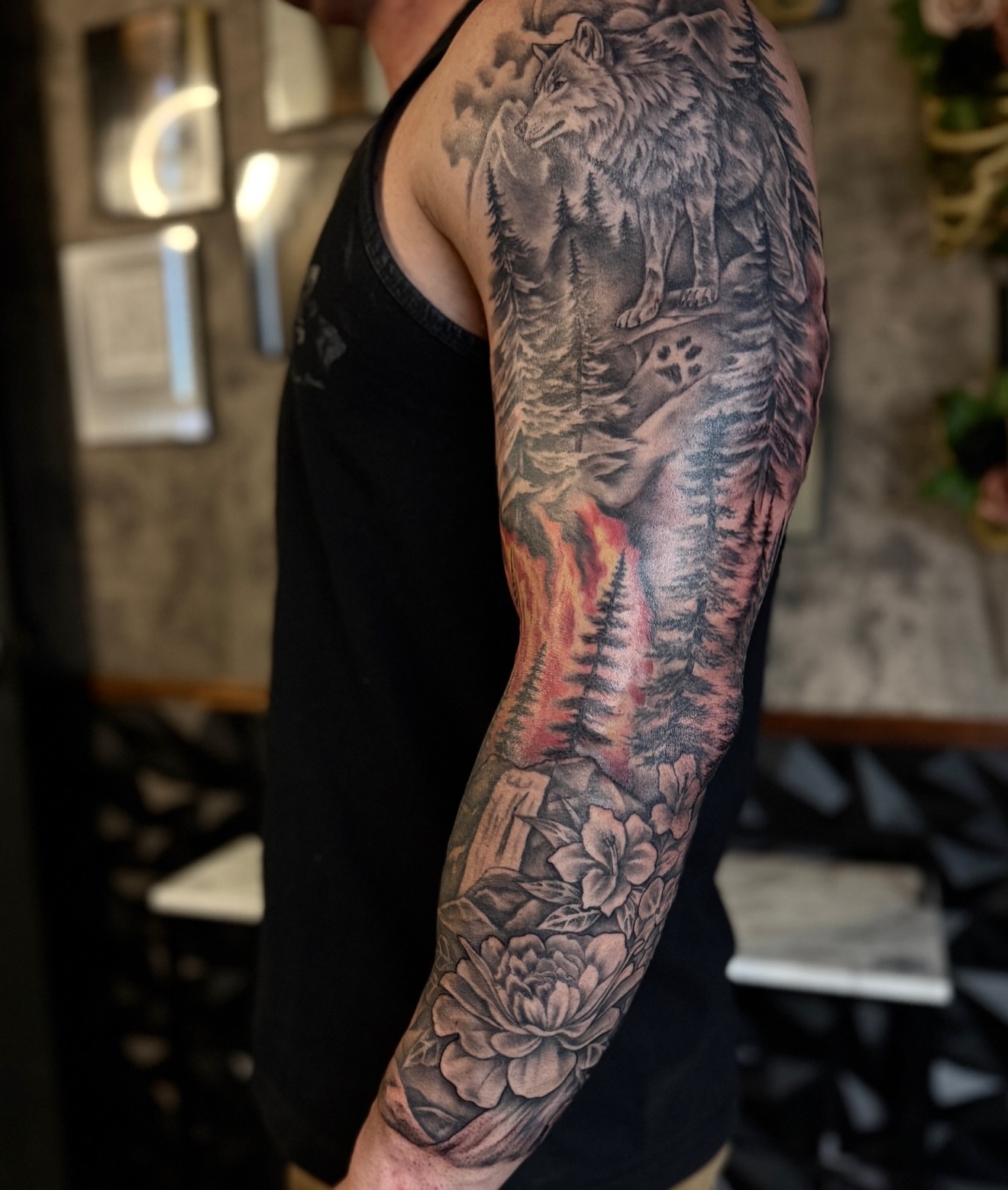 Wolf and forest realism tattoo on the upper arm by Rikky Bobby, Mesa, Arizona