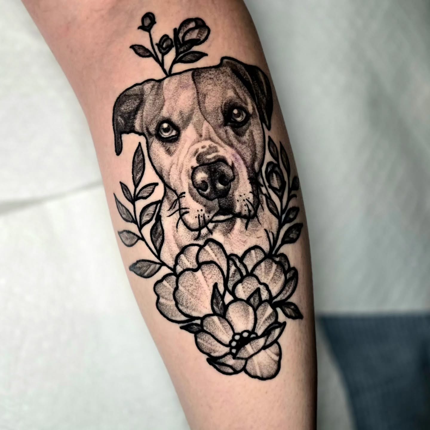 Dog with flowers realism tattoo on the forearm by Adison Essig