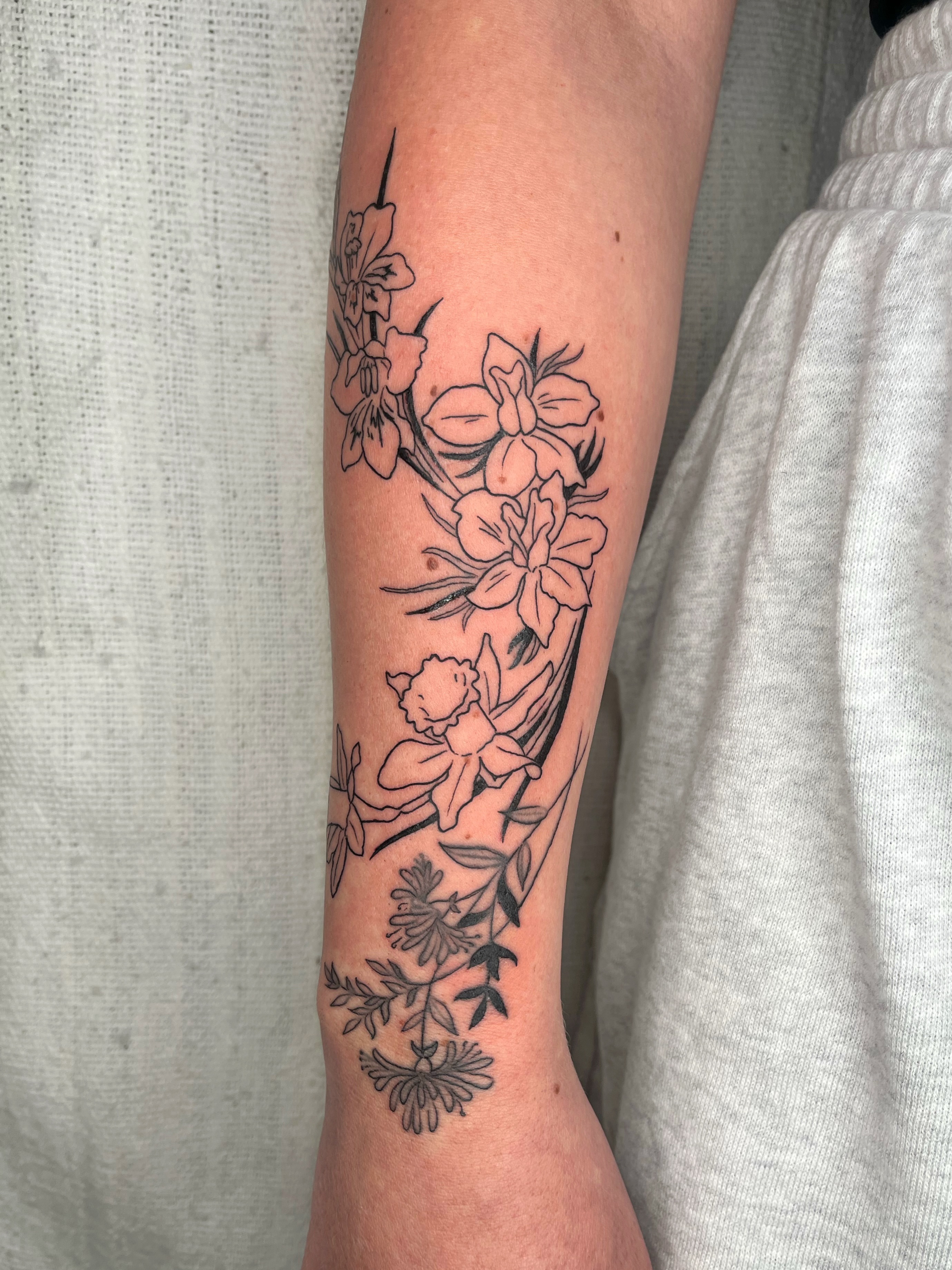 Floral arrangement black and grey tattoo on the forearm by Maris Hare, Philadelphia, Pennsylvania