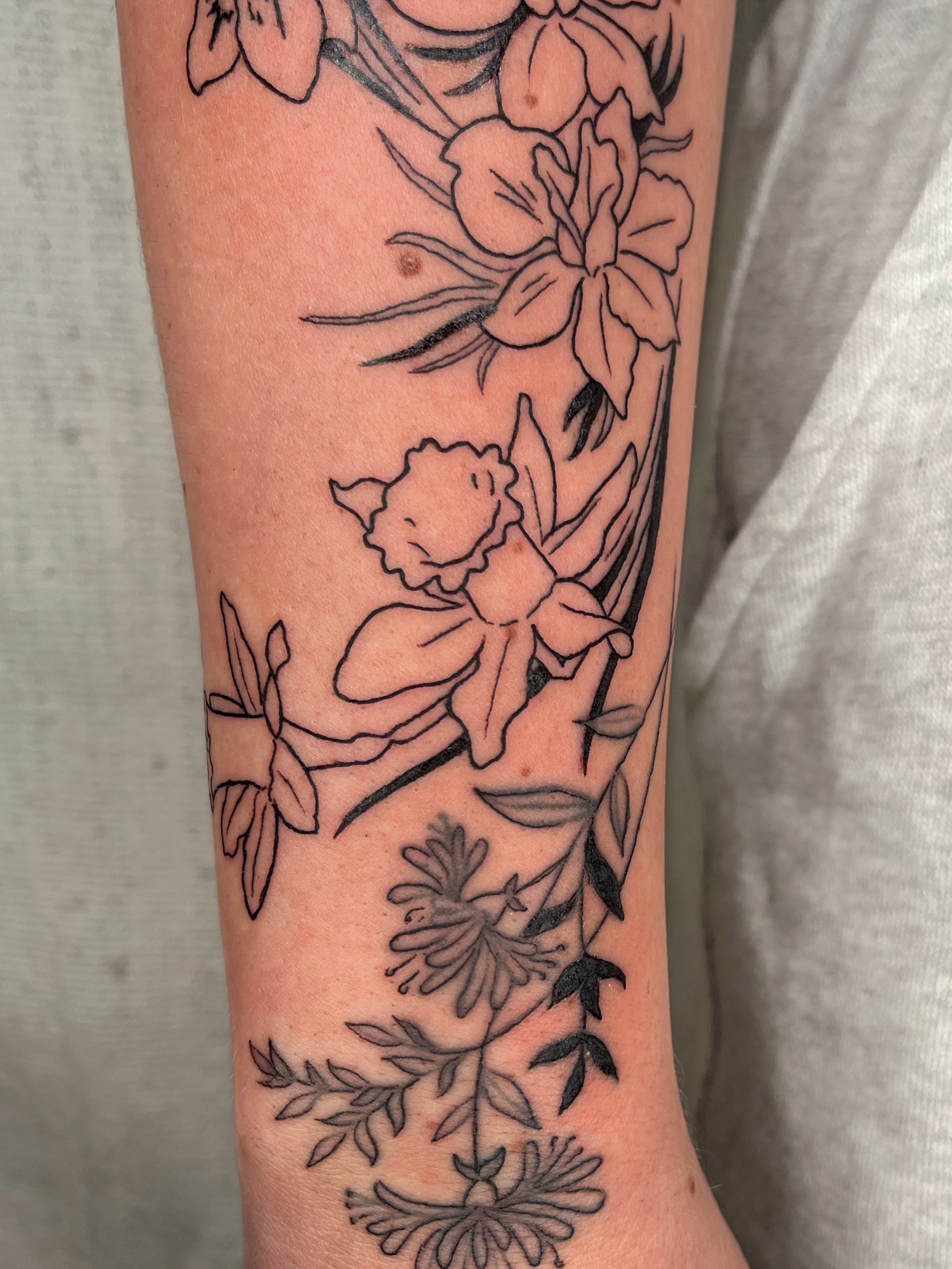 Floral arrangement black and grey tattoo on the forearm by Maris Hare, Philadelphia, Pennsylvania