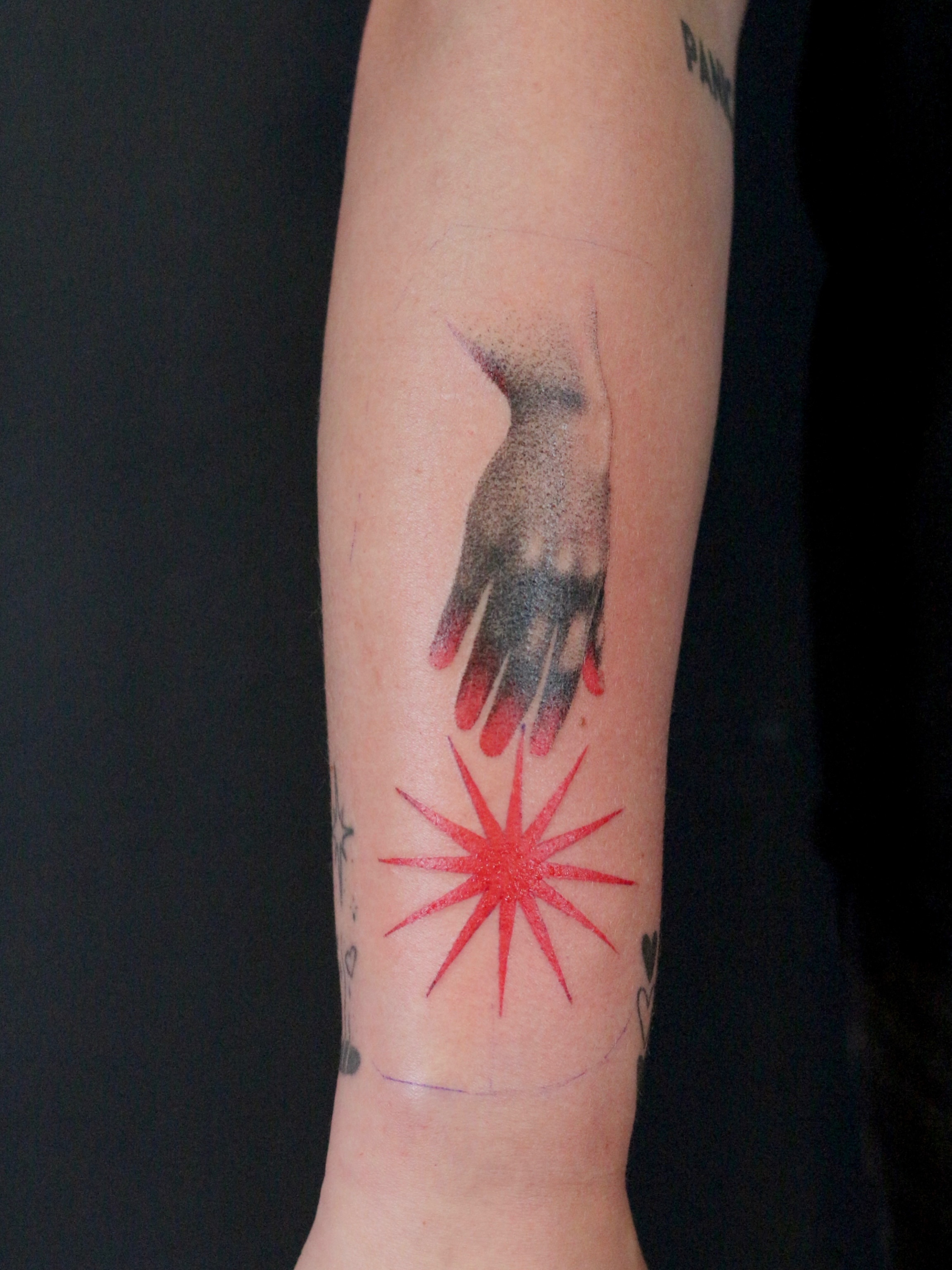 Hand and starburst dotwork tattoo on the forearm by Stephany Victorine