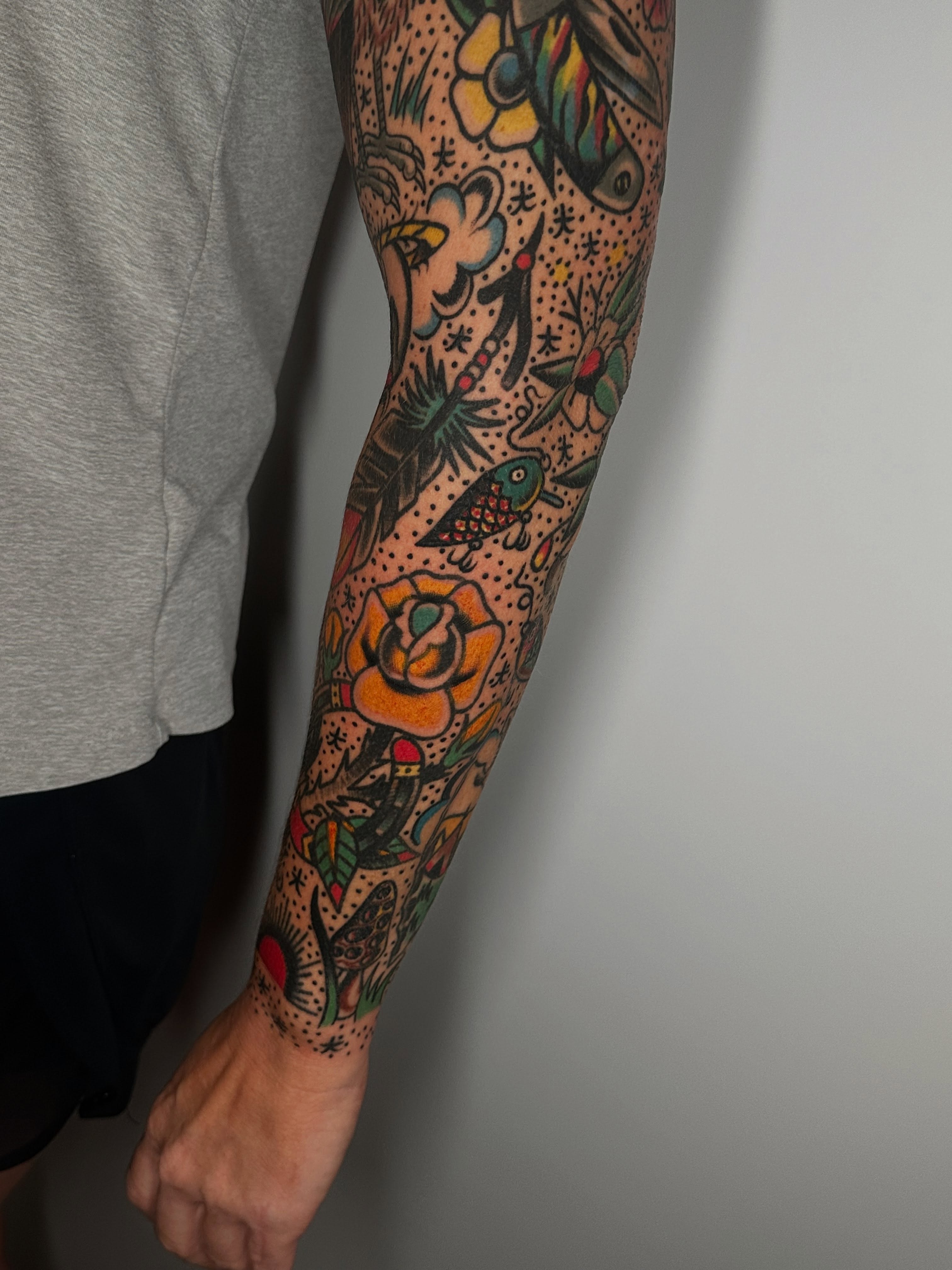 Floral and fish American traditional tattoo on the forearm by Spencer Crawford, Speedway, Indiana