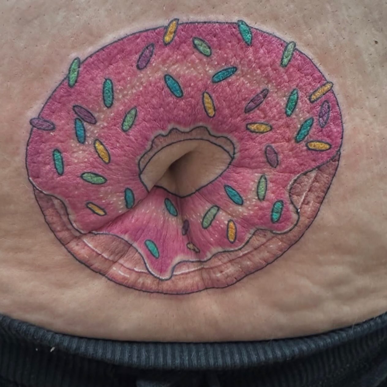 Donut realism tattoo on the torso by Nicki Hoverson