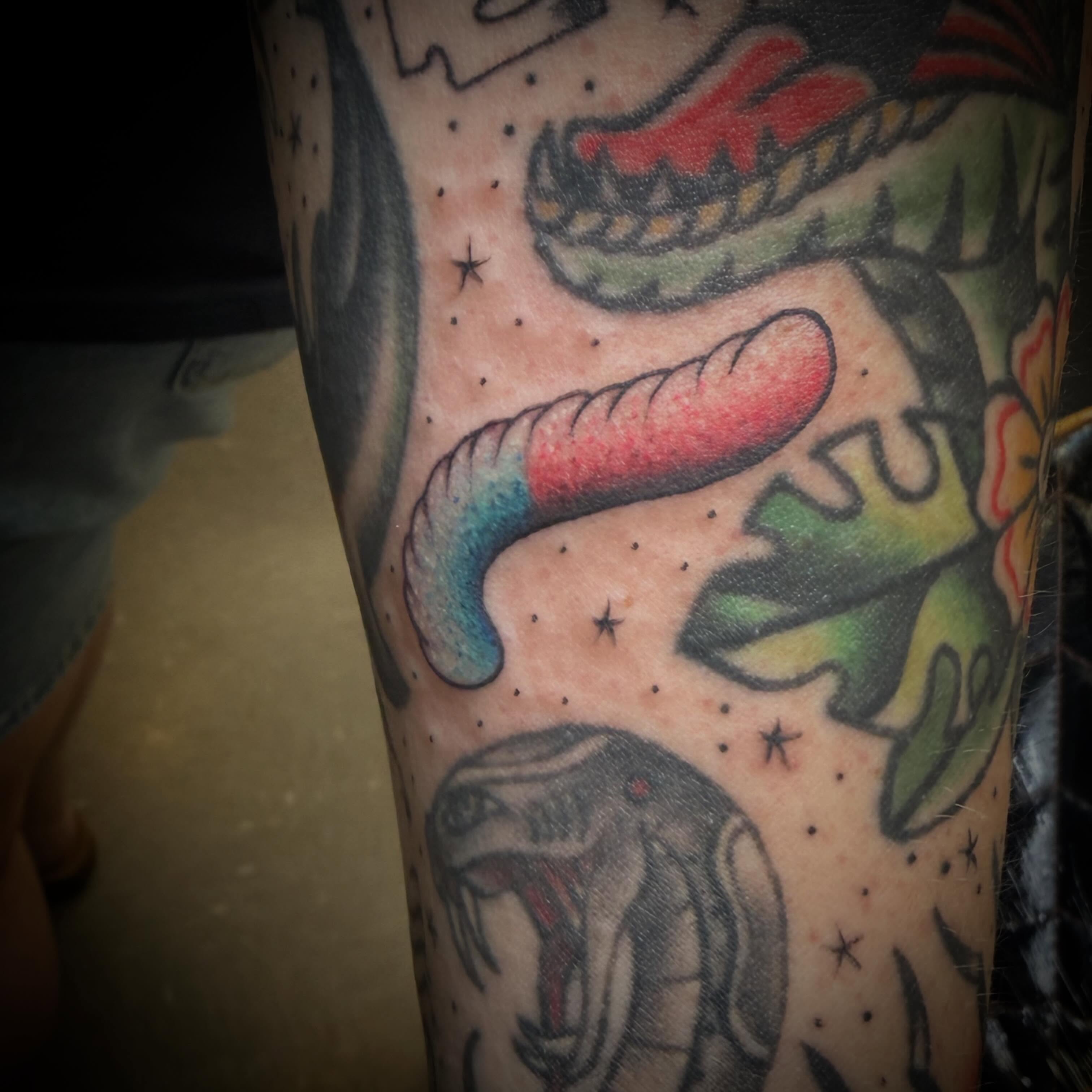 Serpent and hot dog American traditional tattoo on the forearm by ArJay Smith