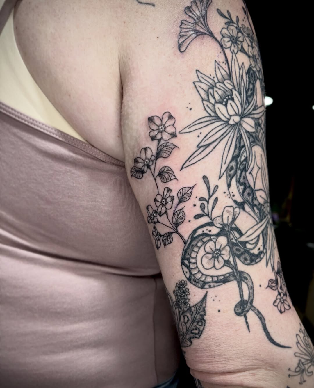 Floral and snake black and grey tattoo on the forearm by destiney rose