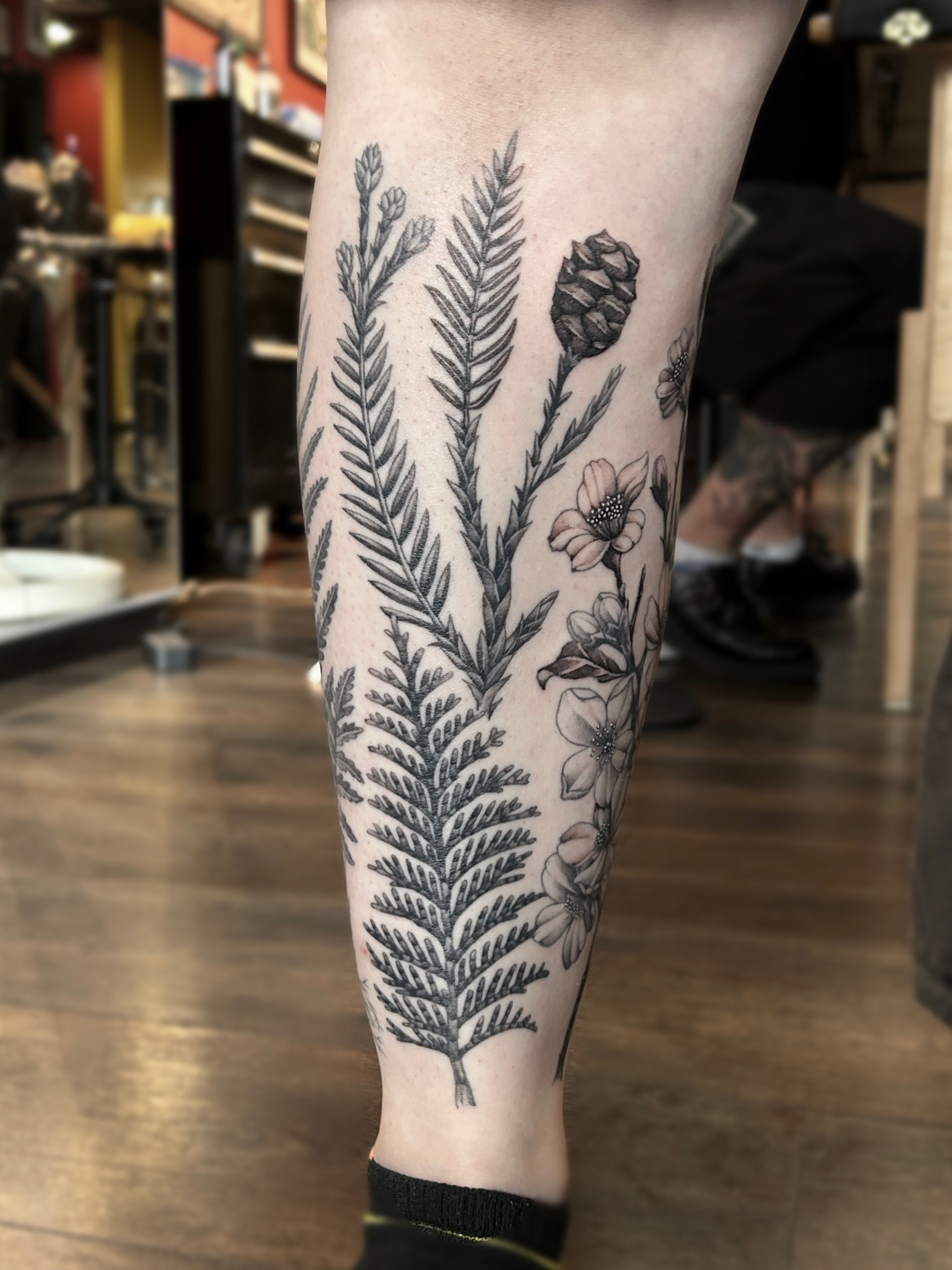 Botanical black and grey tattoo on the calf by Tako, Seattle, Washington