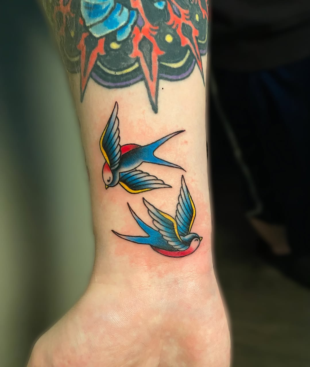 Swallows American traditional tattoo on the forearm by Ezra Gonda