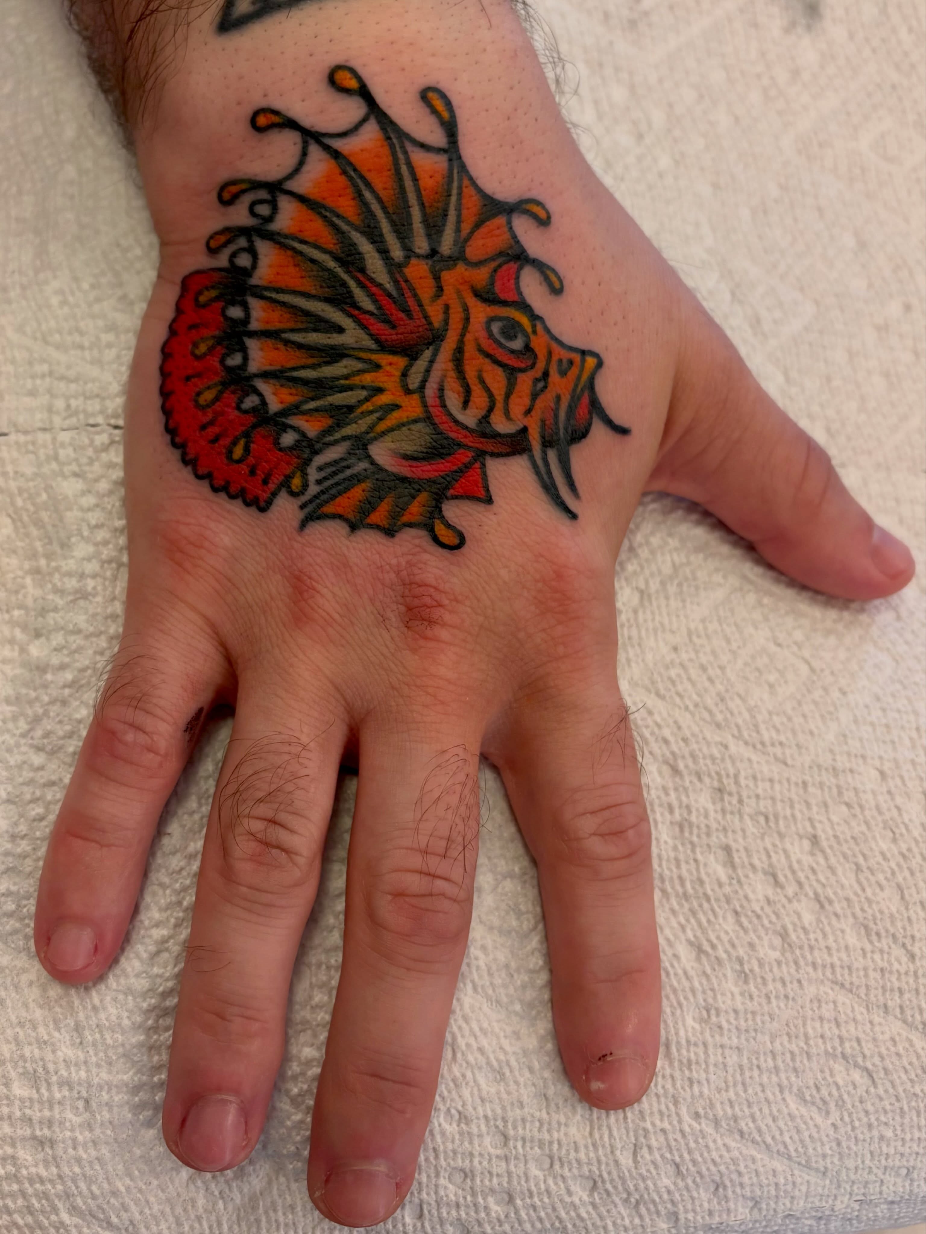 Lionfish American traditional tattoo on the hand by Shane Coslett