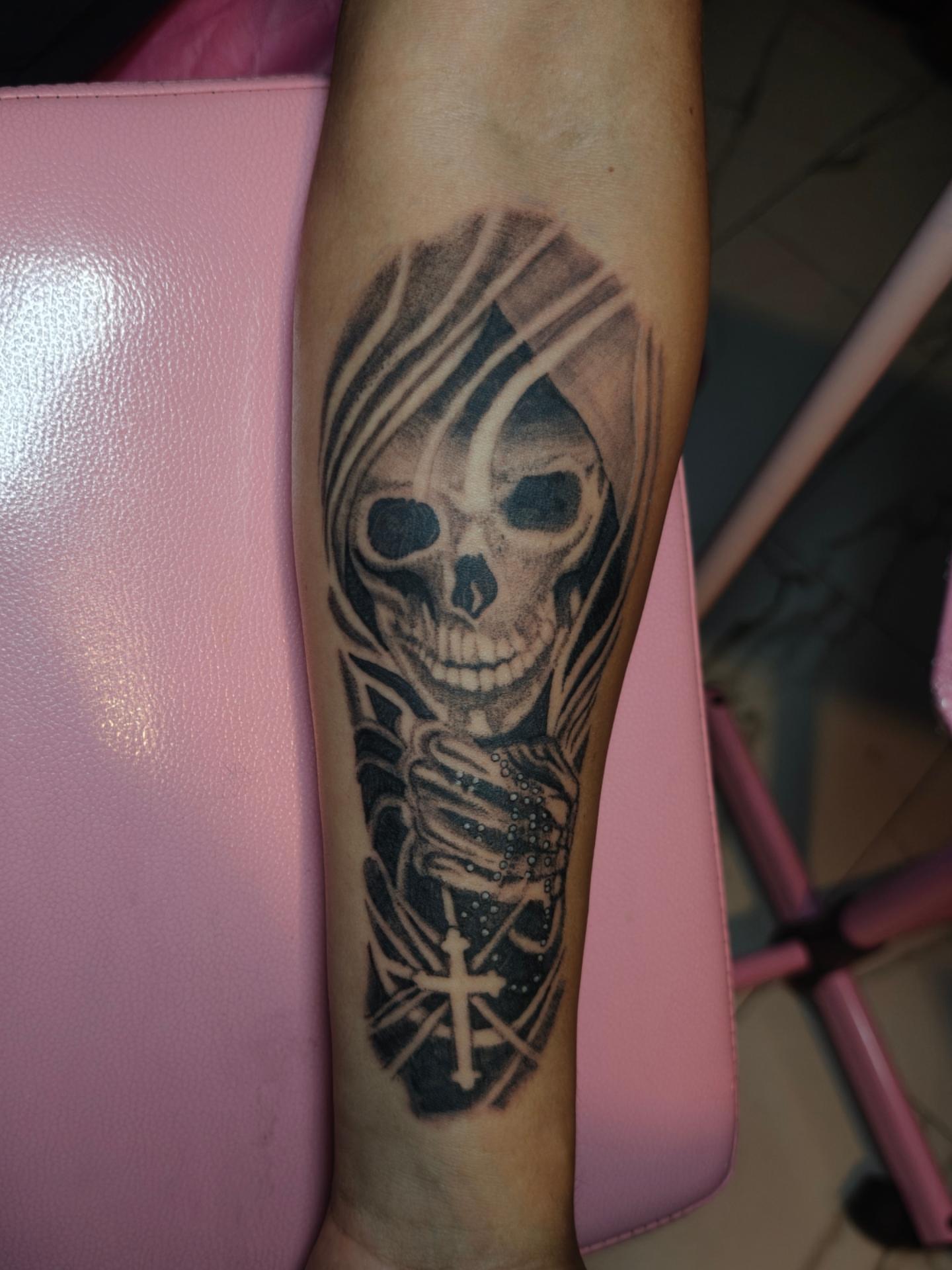 Skull with cross realism tattoo on the forearm by Dani Sandoval, Anaheim, California