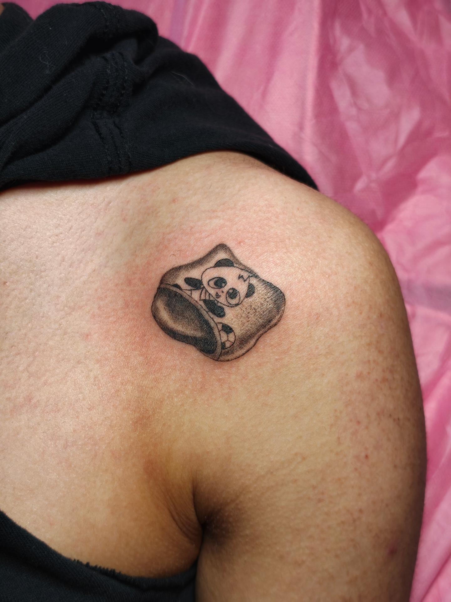Panda in bowl black and grey tattoo on the shoulder by Dani Sandoval, Anaheim, California