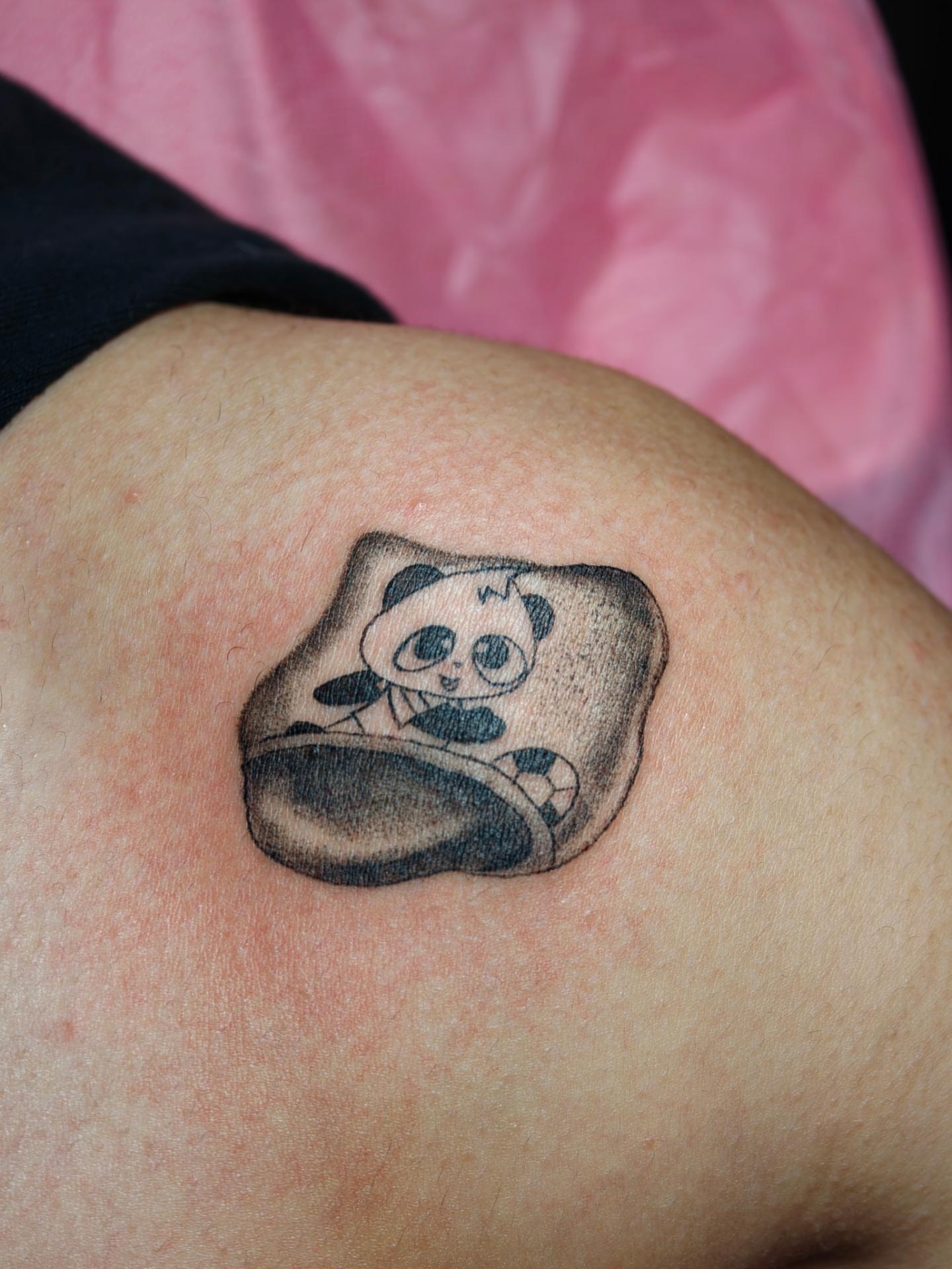Panda toast black and grey tattoo on the thigh by Dani Sandoval, Anaheim, California