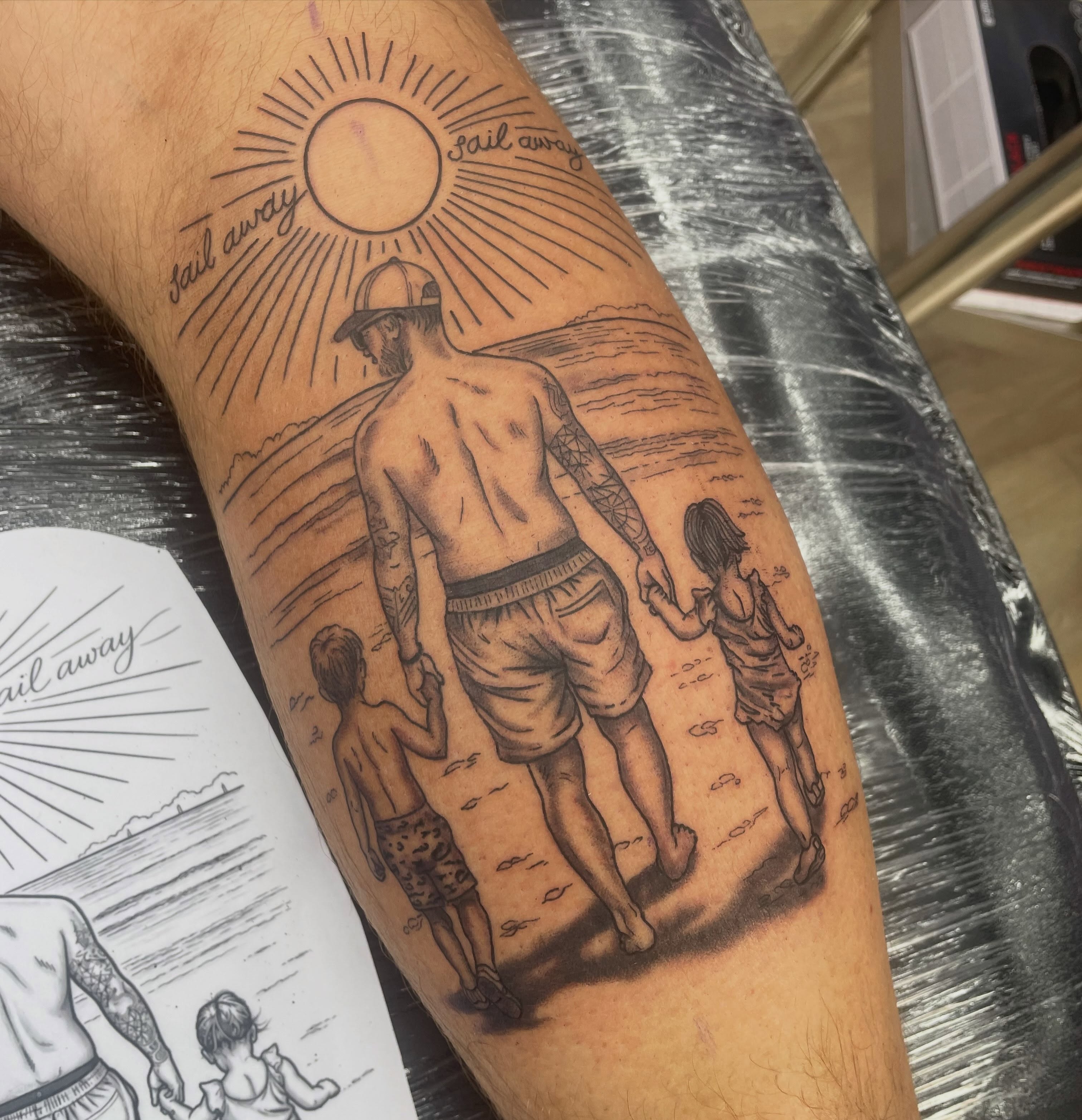 Beach family scene realism tattoo on the forearm by elly, Oakham