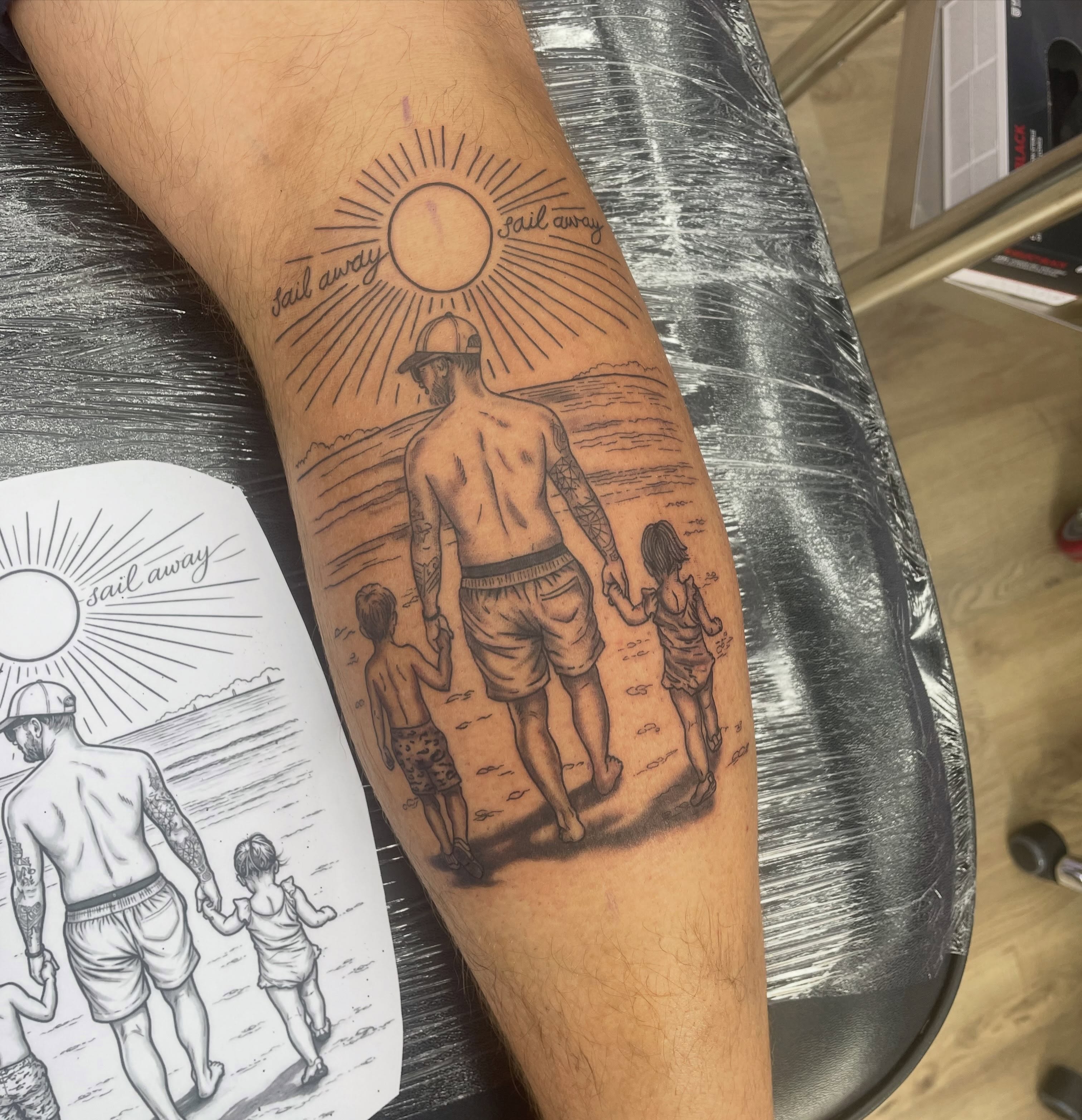 Beach family scene realism tattoo on the forearm by elly, Oakham