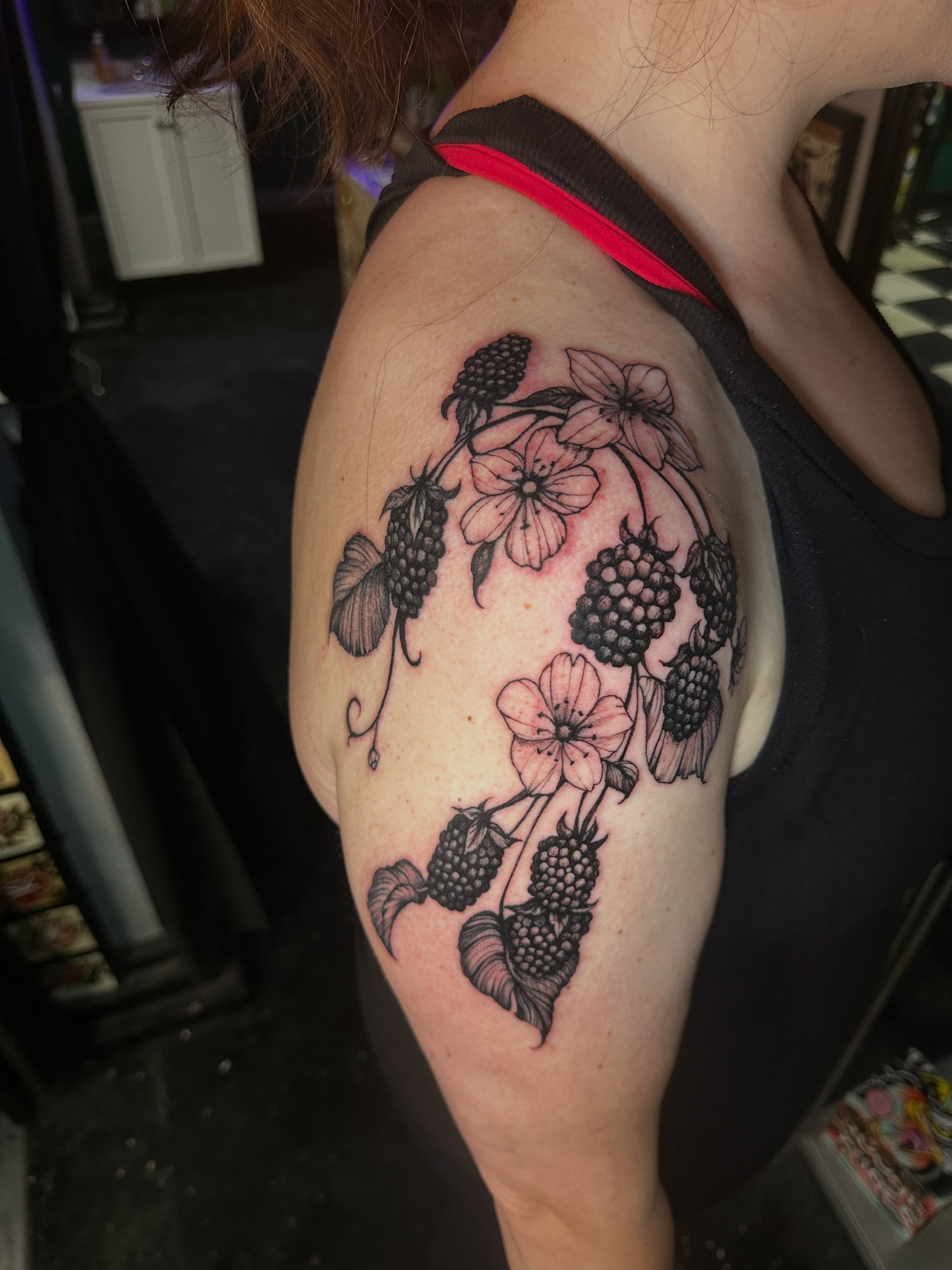 Berries and flowers black and grey tattoo on the shoulder by Matthew Tattooer Harman