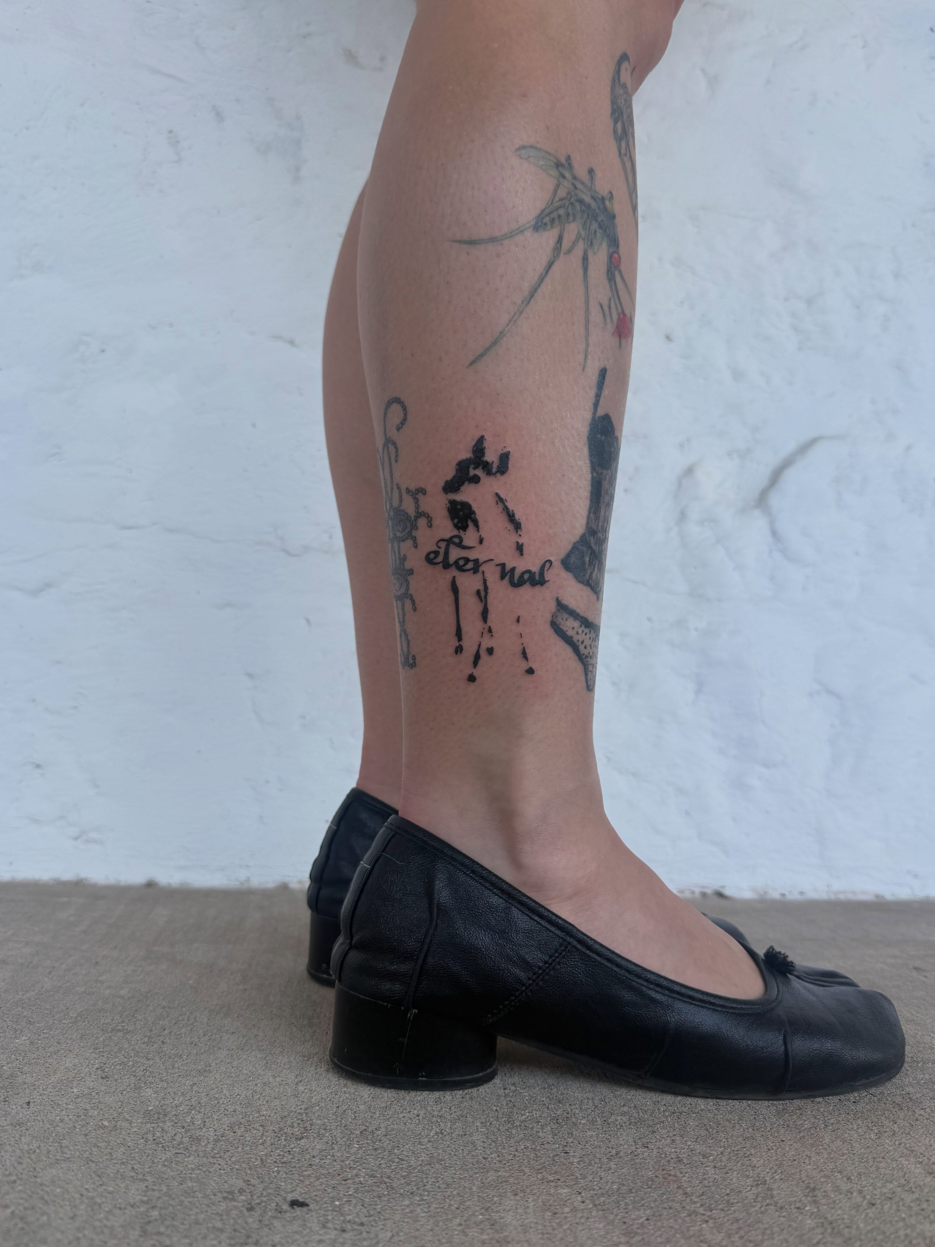 Skull and crossbones black and grey tattoo on the calf by sarah