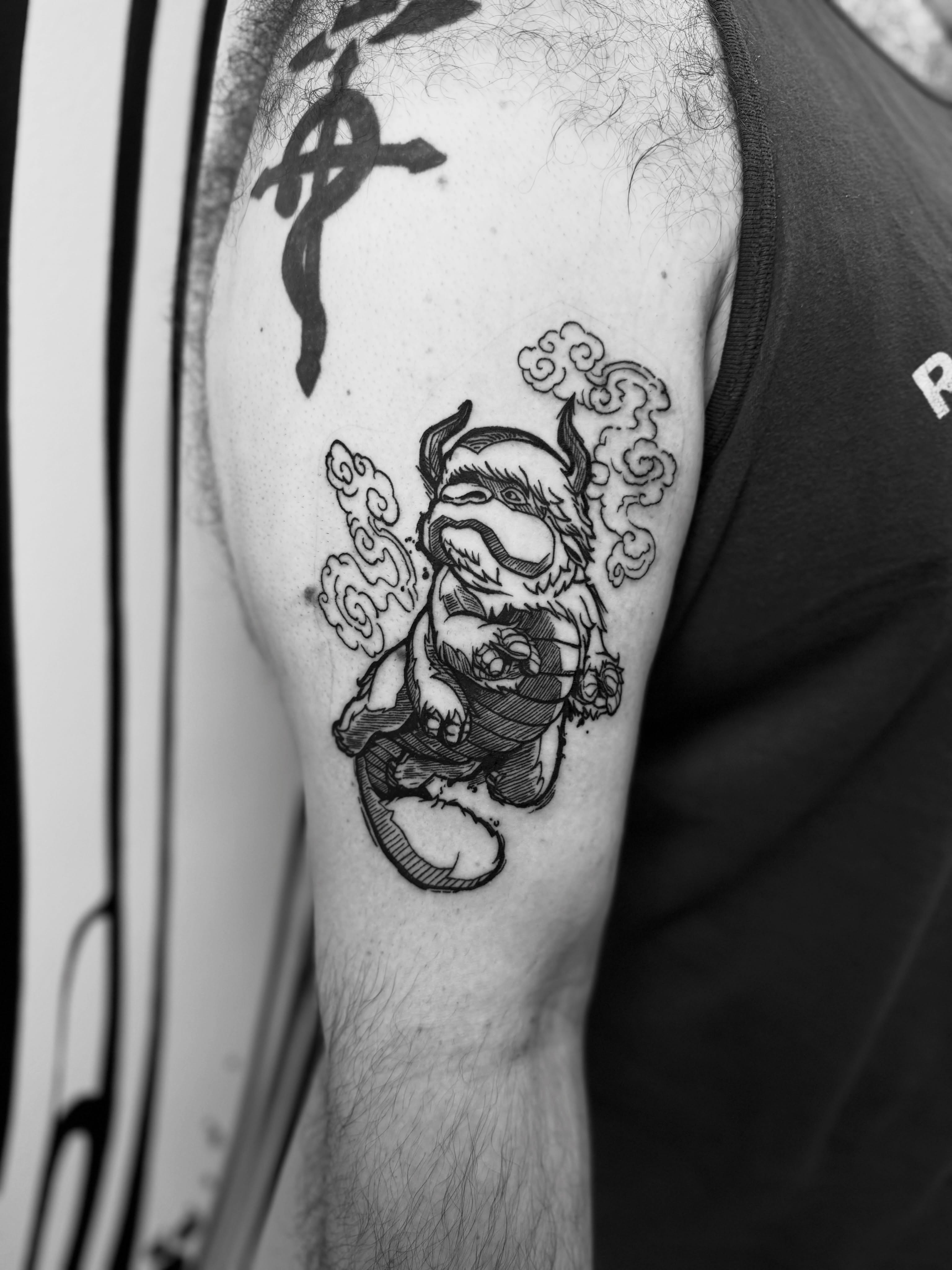 Monster black and grey tattoo on the upper arm by Joey Taylor