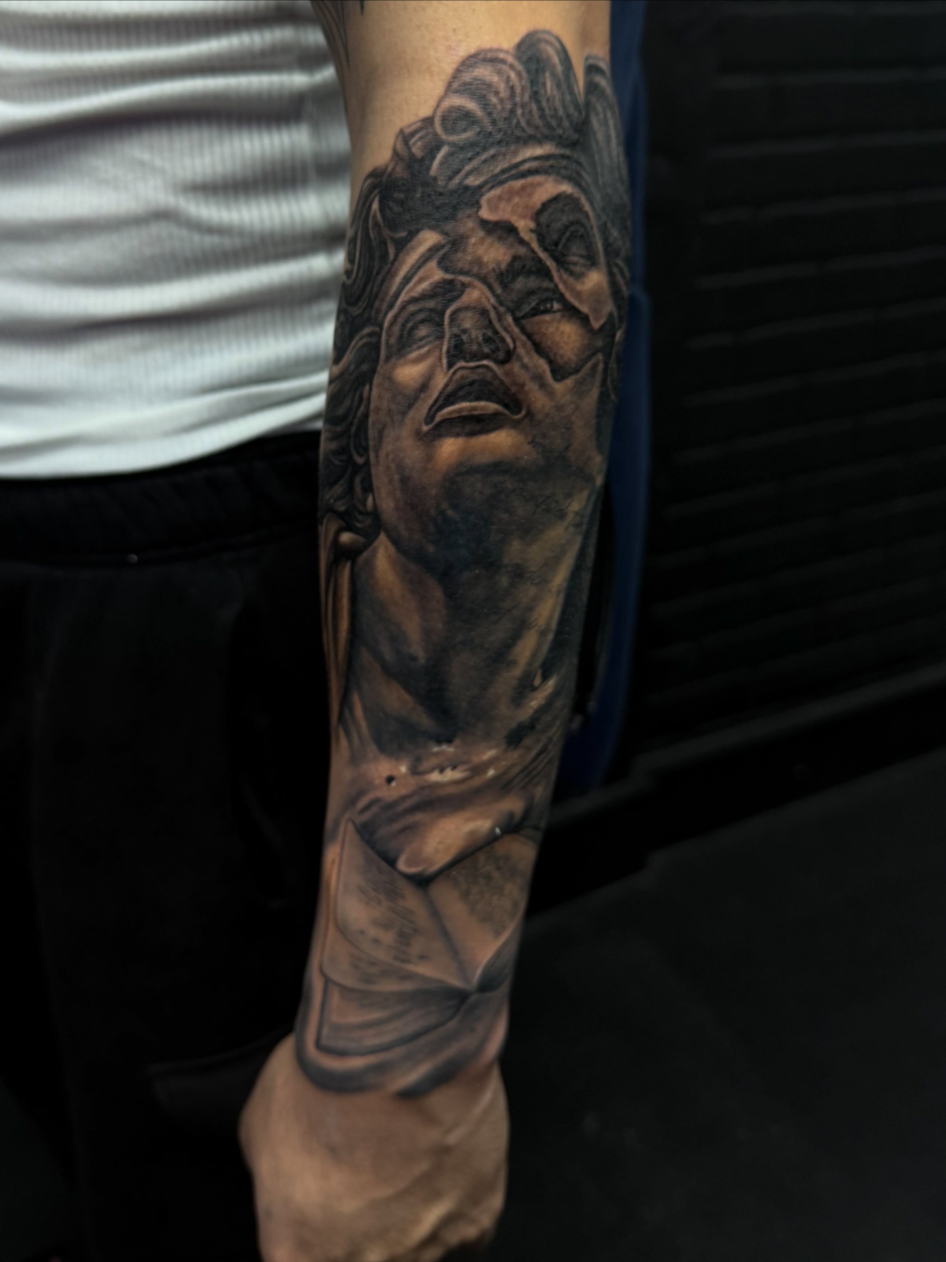 Statue head realism tattoo on the forearm by Kiefer Fonseca
