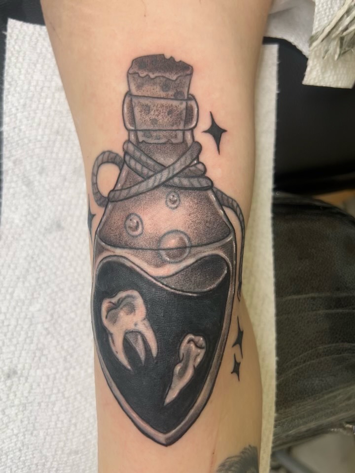 Bottle with teeth dotwork tattoo on the forearm by Reilley Earles