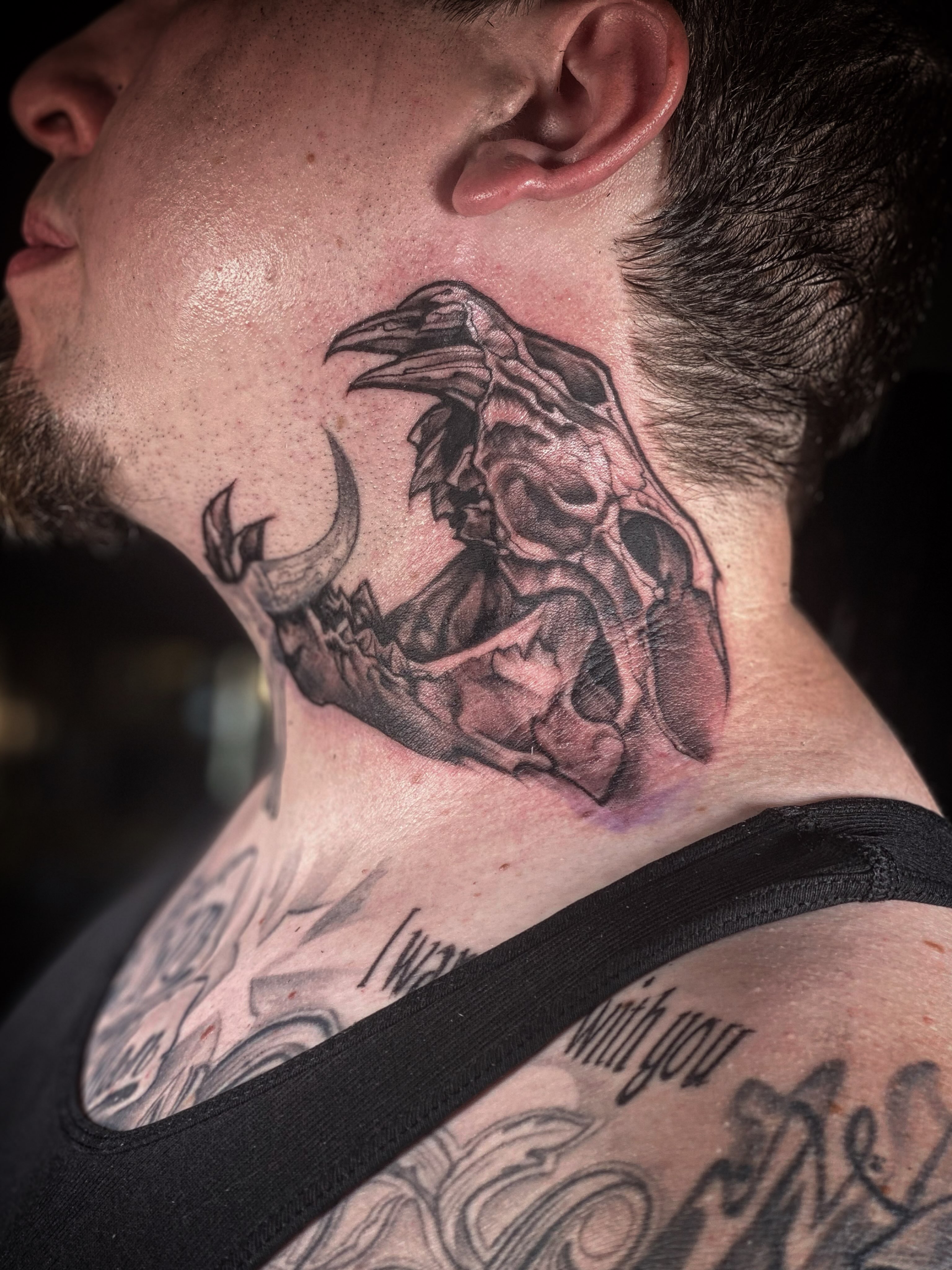 Raven skull black and grey tattoo on the neck by Chris Klee