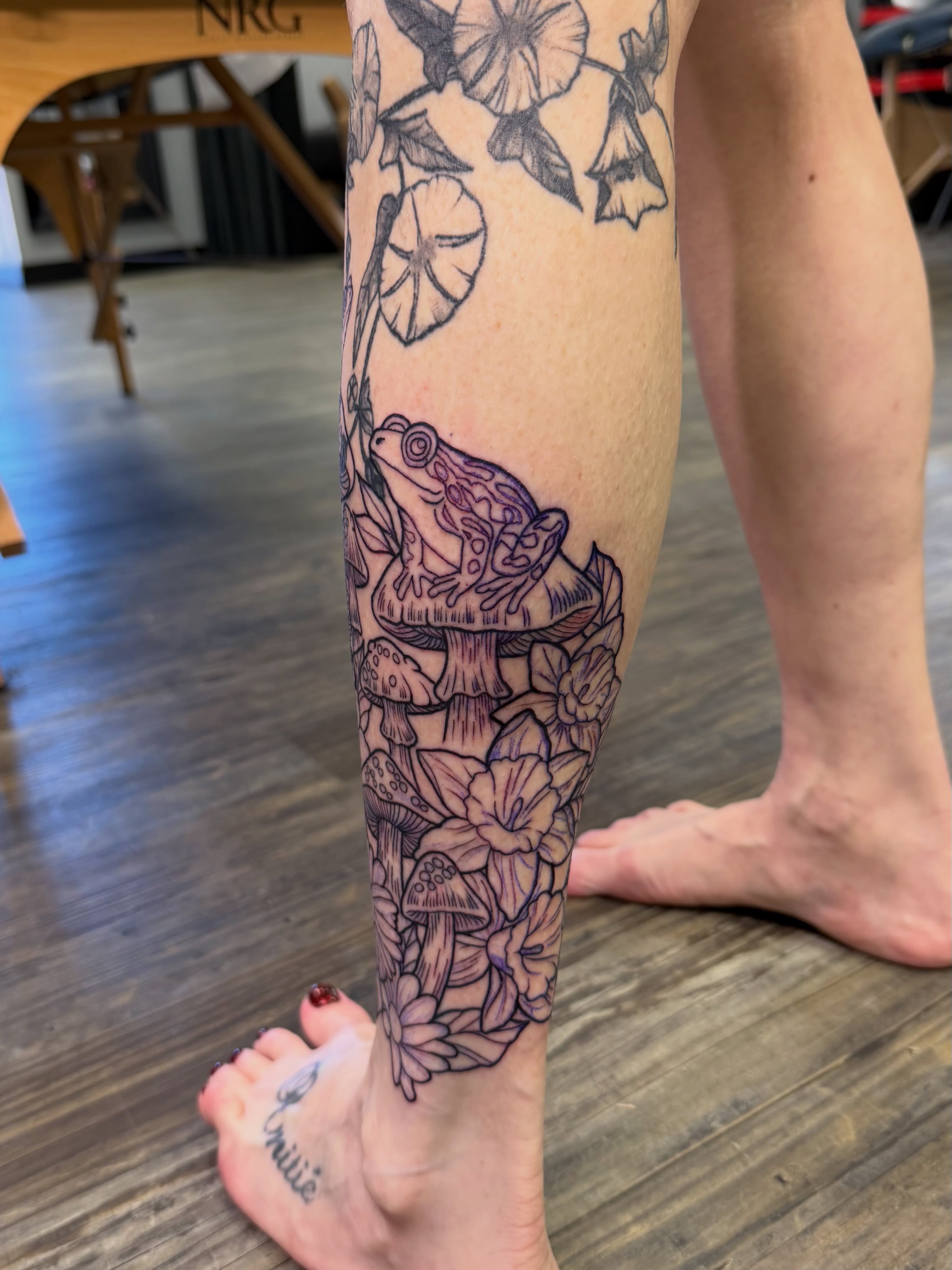 Frog and flowers black and grey tattoo on the calf by TyAnne Schulte