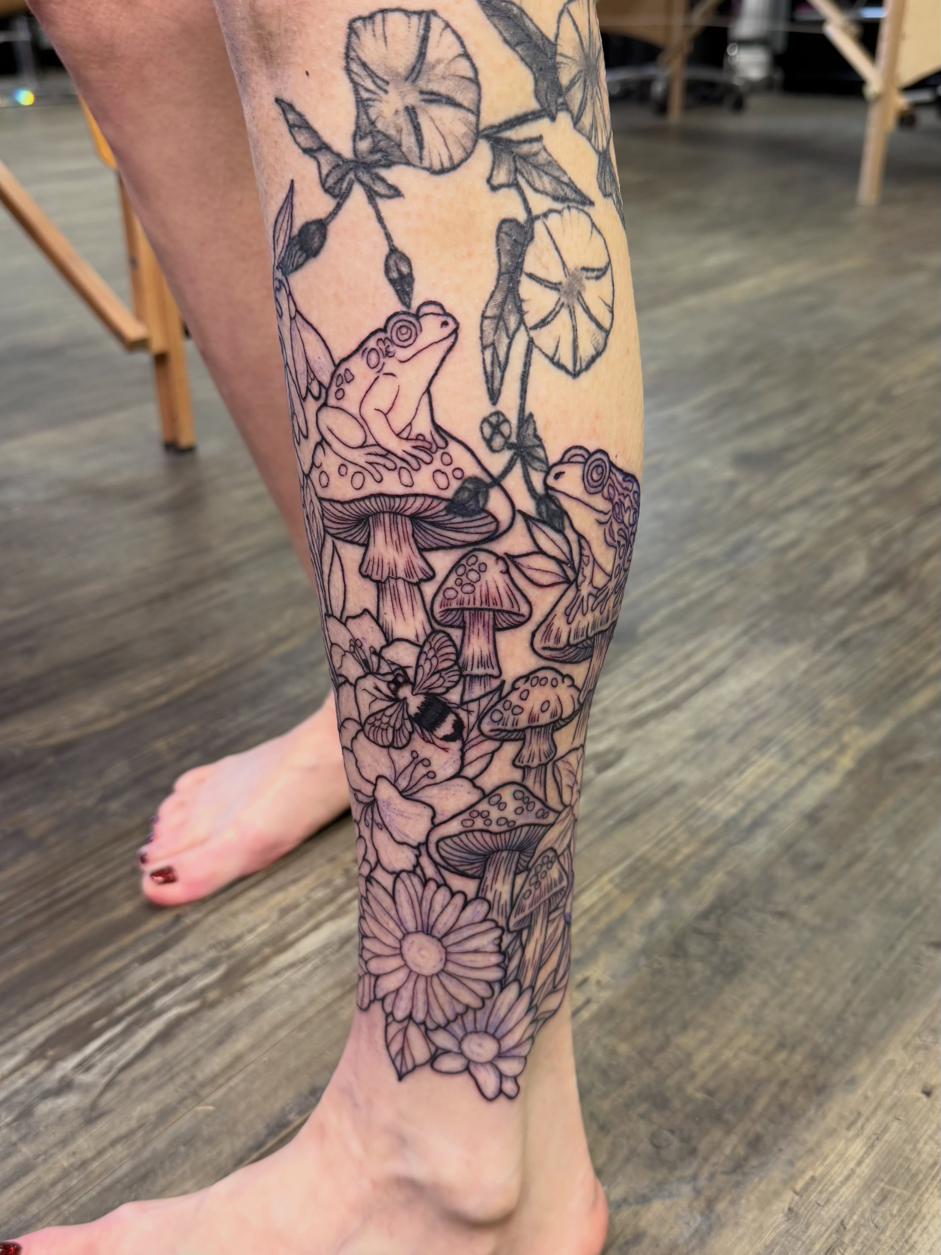 Frogs and mushrooms black and grey tattoo on the calf by TyAnne Schulte