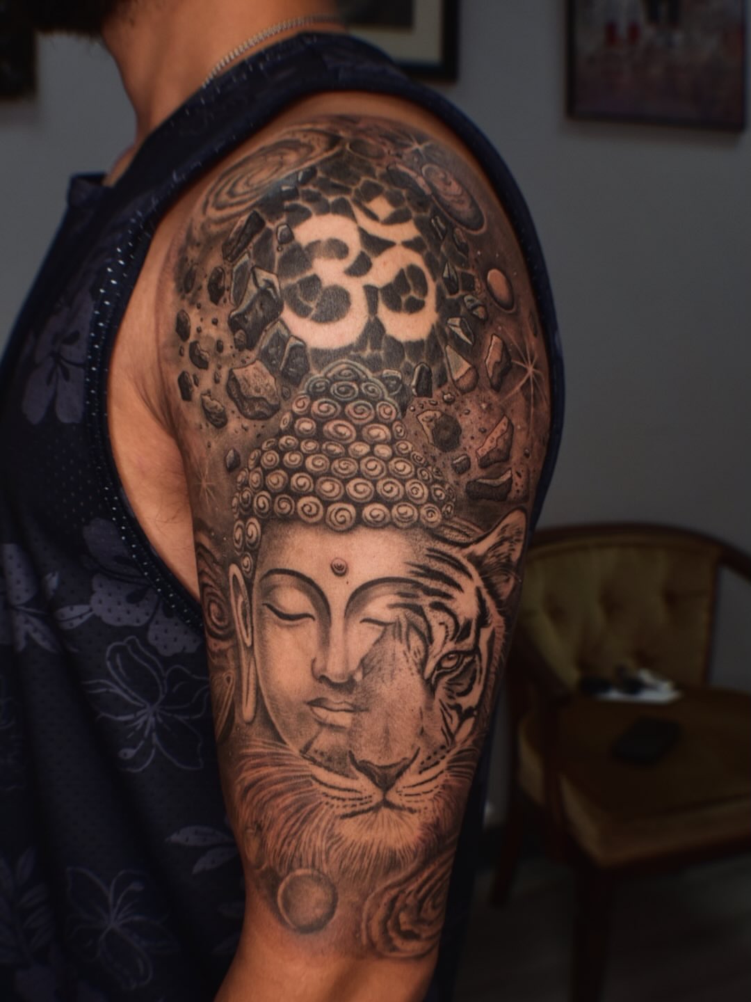 Buddha head with om symbol realism tattoo on the shoulder by Alexandria Gudiel