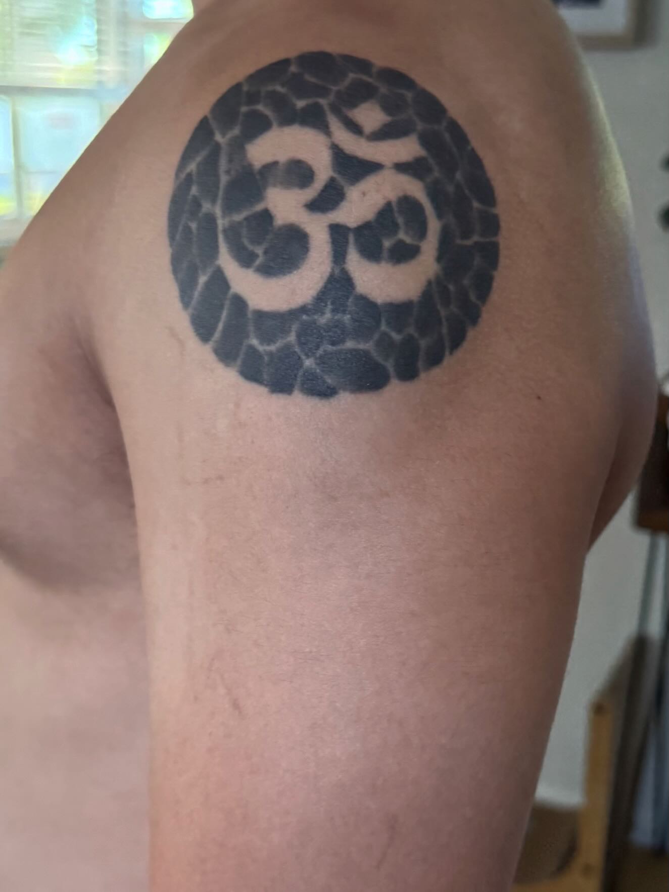 Om symbol black and grey tattoo on the shoulder by Alexandria Gudiel