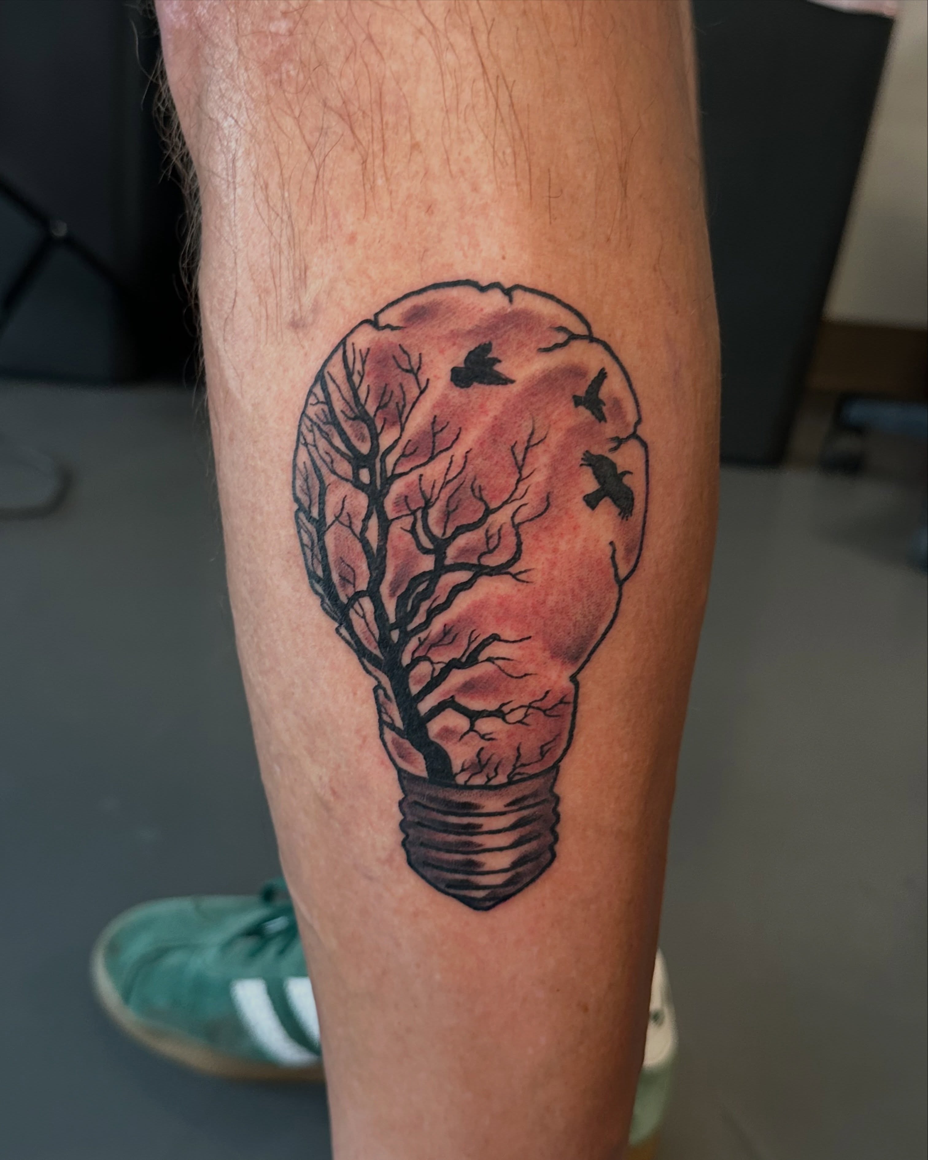 Light bulb with tree realism tattoo on the forearm by Nick Bones, Las Vegas, Nevada