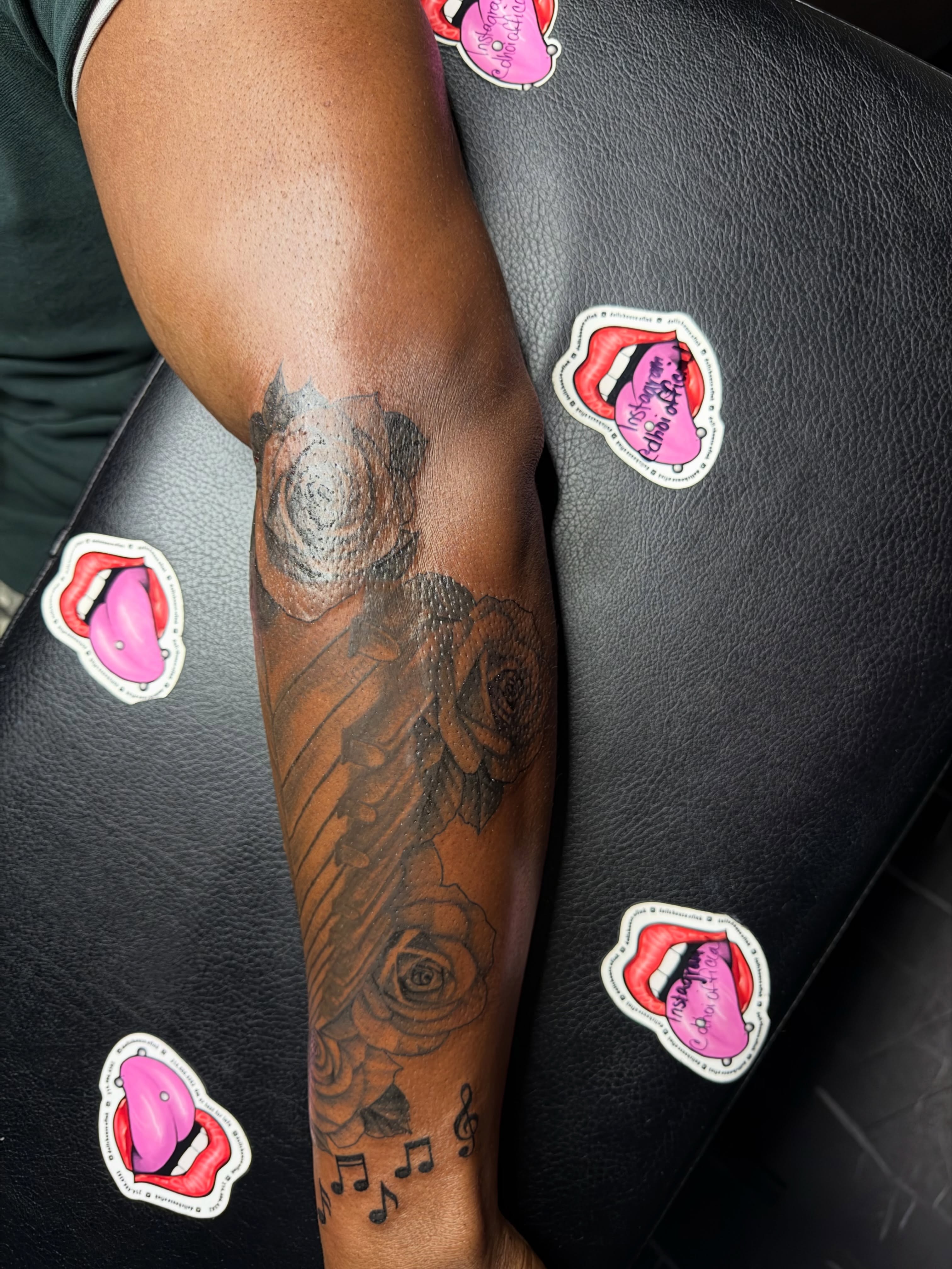 Roses and musical notes black and grey tattoo on the forearm by Doll The Tattoo Artist, Addison, Texas