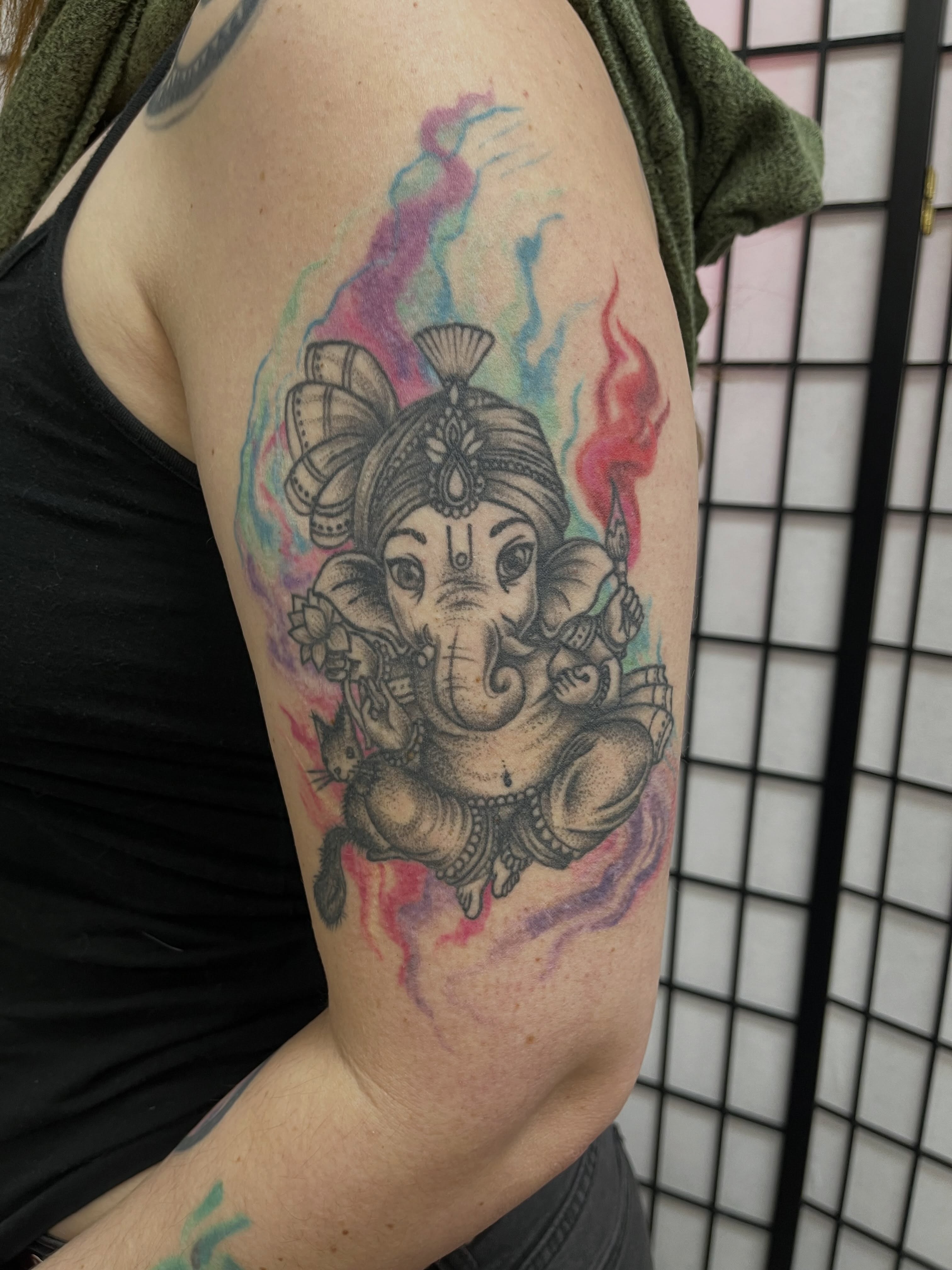 Ganesha new school tattoo on the upper arm by Lauryn Dunkle