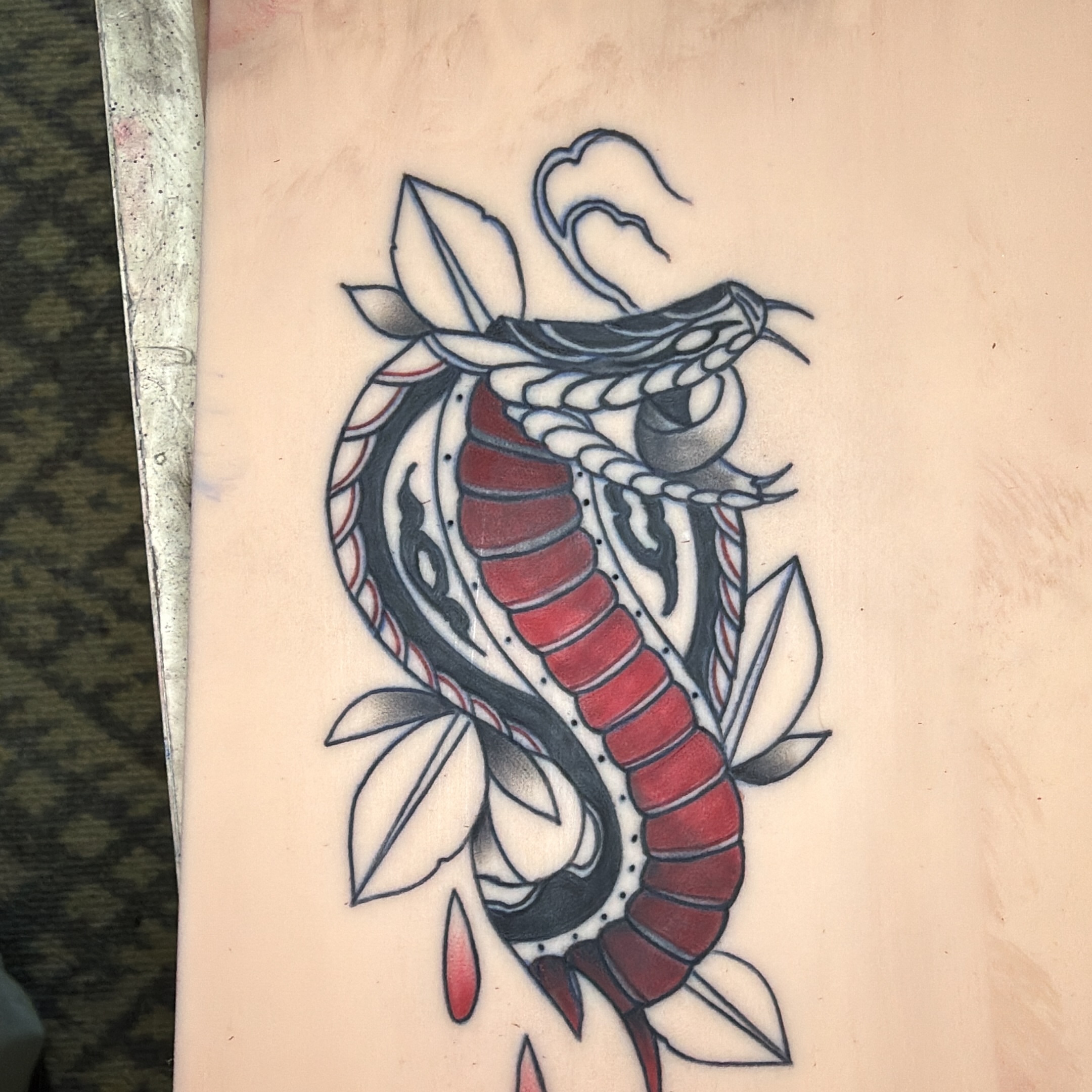 Snake American traditional tattoo on the upper arm by Addison Bruce